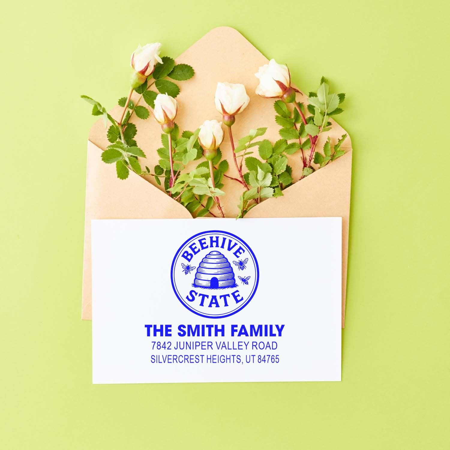 Custom return address rubber stamp with Beehive State design for The Smith Family on a floral envelope.