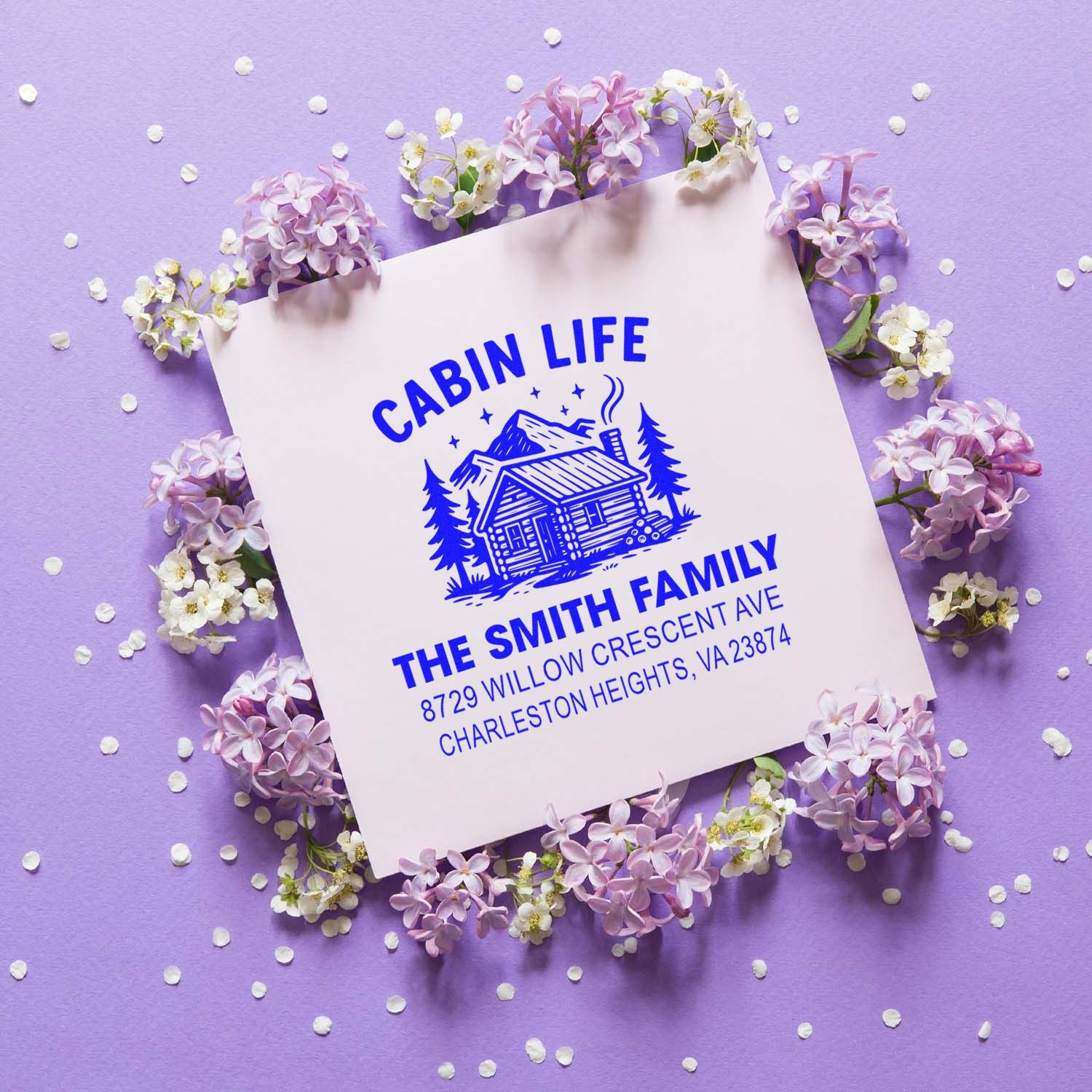 Personalized cabin life rubber stamp with rustic log cabin logo, family name, and address for custom mailing.