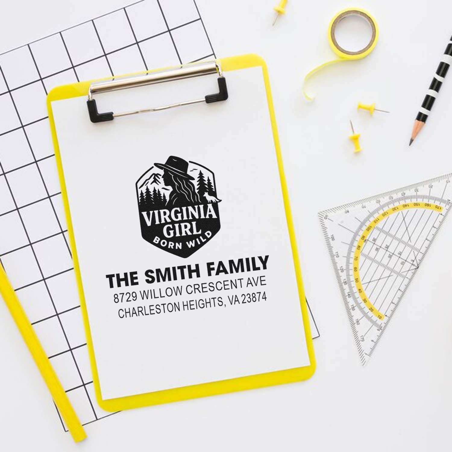 Personalized self-inking address stamp for The Smith Family, featuring Virginia Girl Born Wild logo on a clipboard with stationery tools on a white desk.