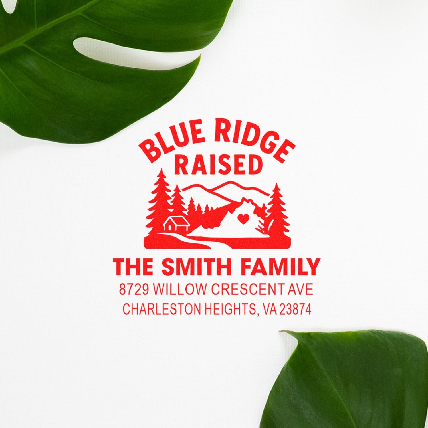 Custom red Blue Ridge Raised family address stamp with mountain, trees, cabin and heart design on a white background with green leaves.