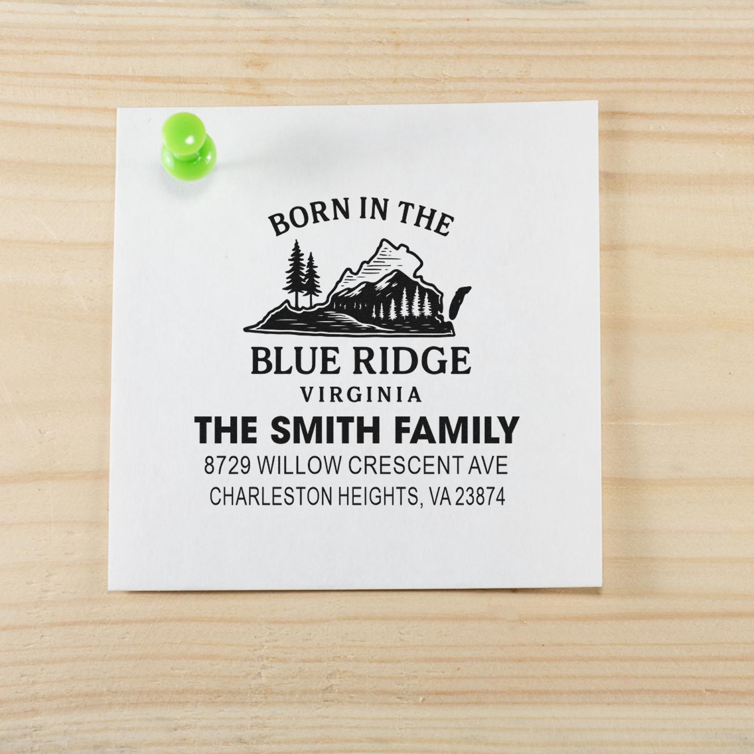 Custom return address stamp for The Smith Family, Born in the Blue Ridge, Virginia, on white paper pinned to a wooden tabletop.