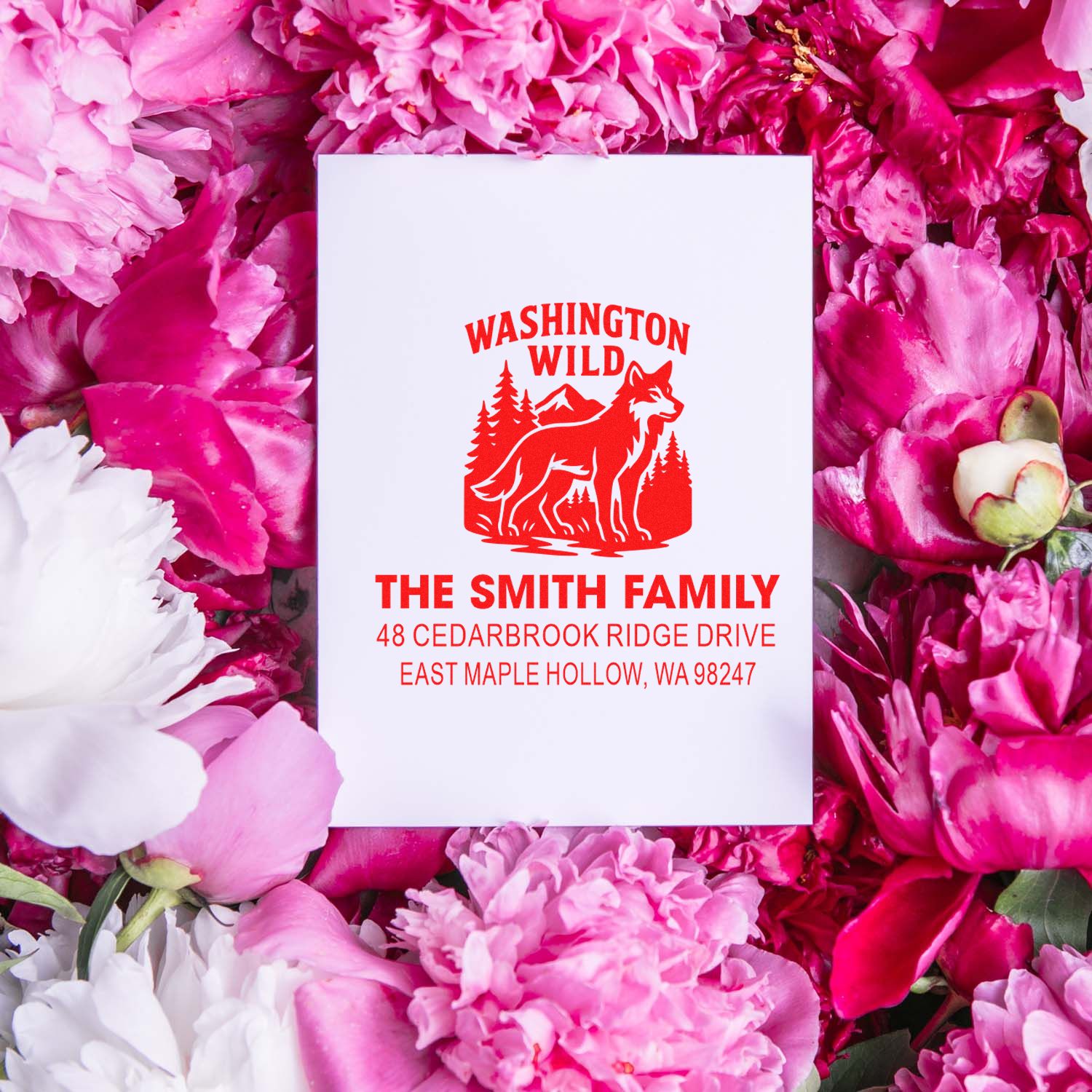 Custom Washington Wild return address stamp with wolf and pine design, displayed on pink and white peonies.