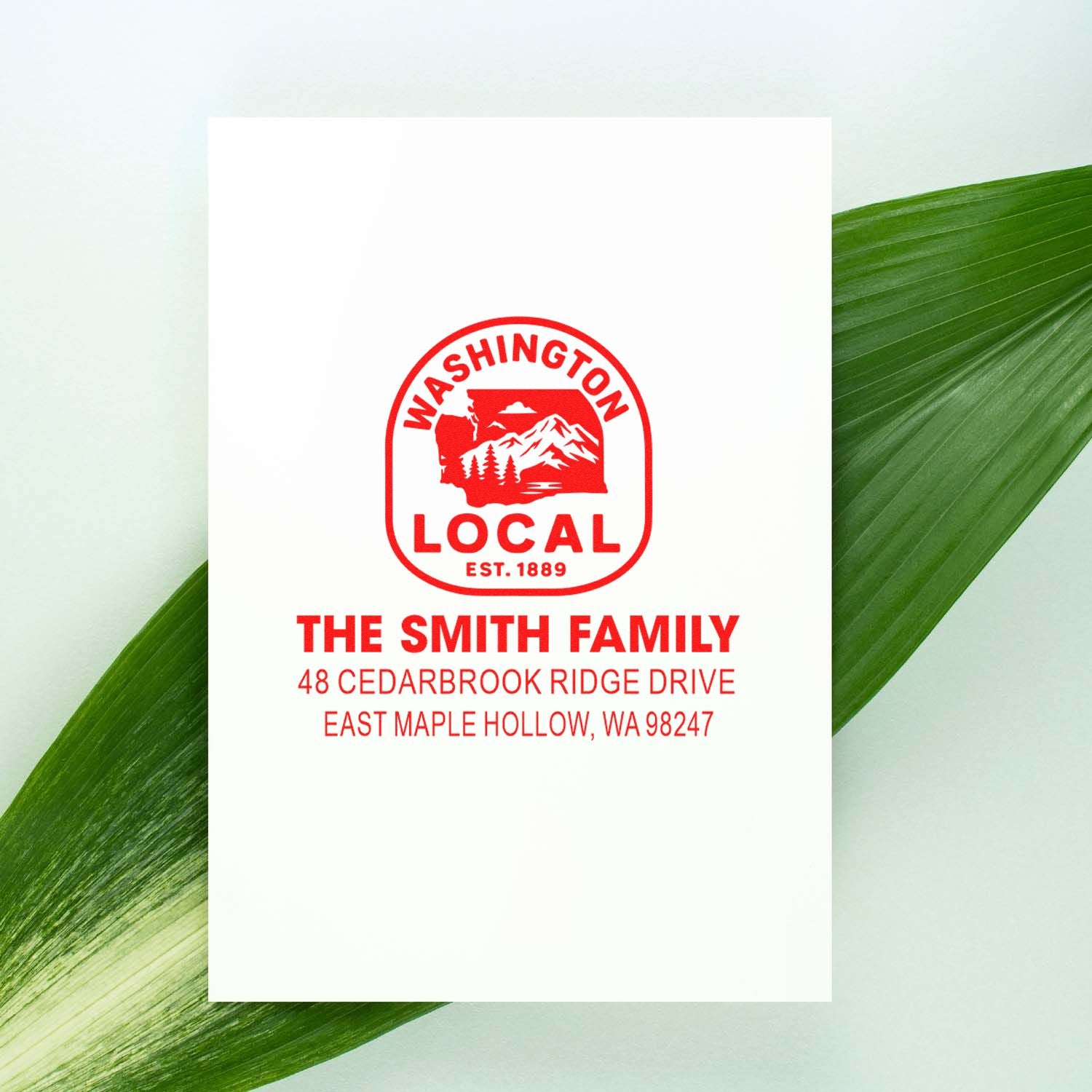 Custom Washington Local address stamp for The Smith Family on white card, styled over green leaves.