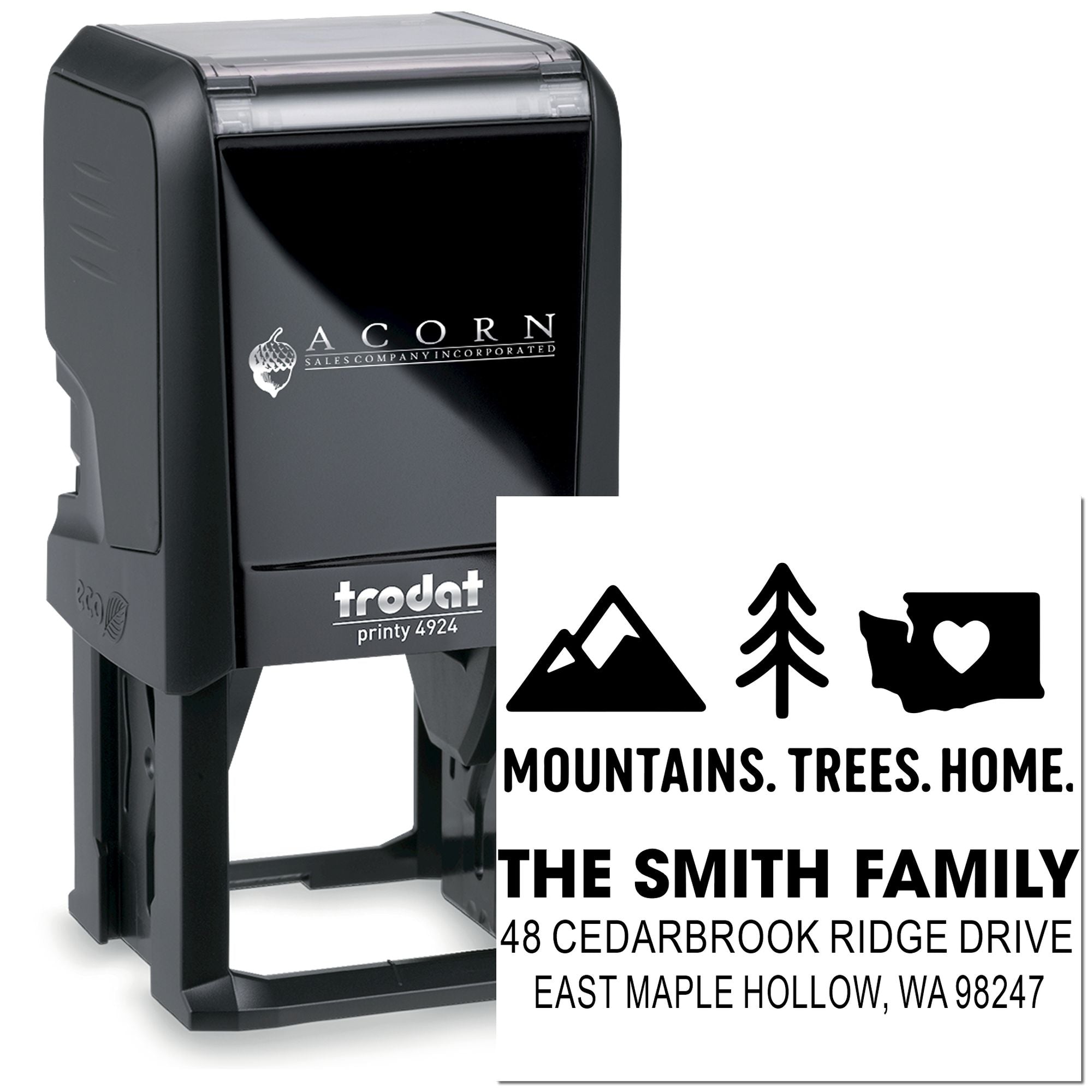 Black Trodat self-inking address stamp with custom mountain, tree and home design, showing The Smith Family name and mailing address on a white background.