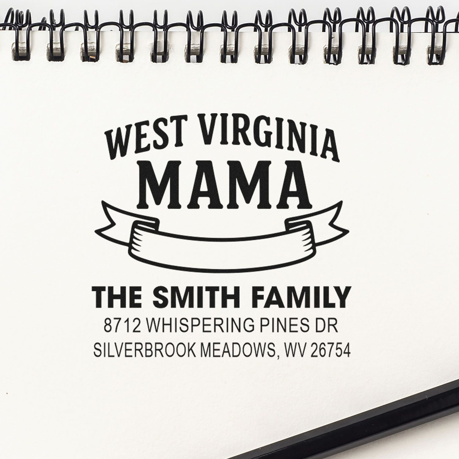 Custom West Virginia Mama address stamp for The Smith Family, featuring a return address and decorative banner on a spiral-bound notebook.