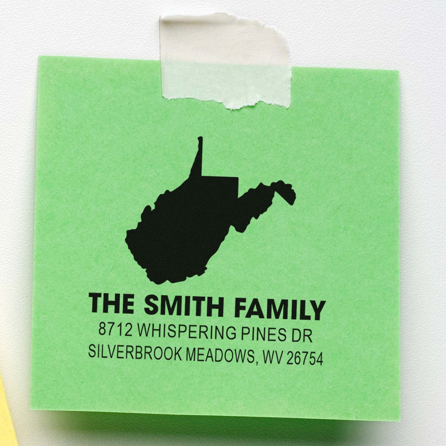 Custom address stamp for The Smith Family with West Virginia silhouette on green paper, taped at top with masking tape.