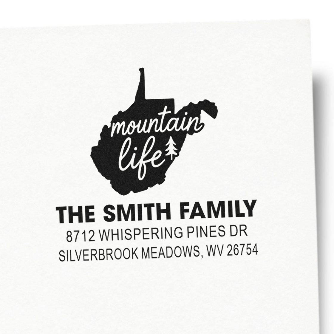 Custom return address stamp with West Virginia mountain outline, mountain life text, and The Smith Family address on white paper.
