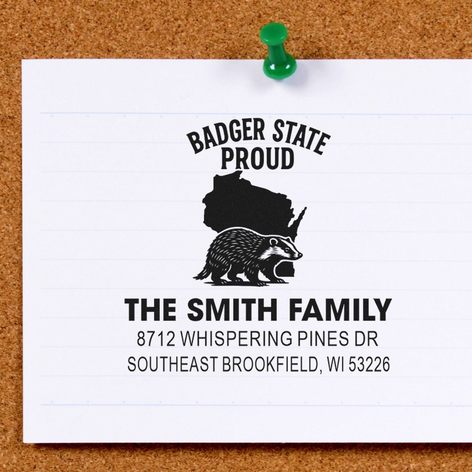 Custom Wisconsin address stamp reading Badger State Proud with badger and state silhouette, pinned on corkboard beside The Smith Family address.