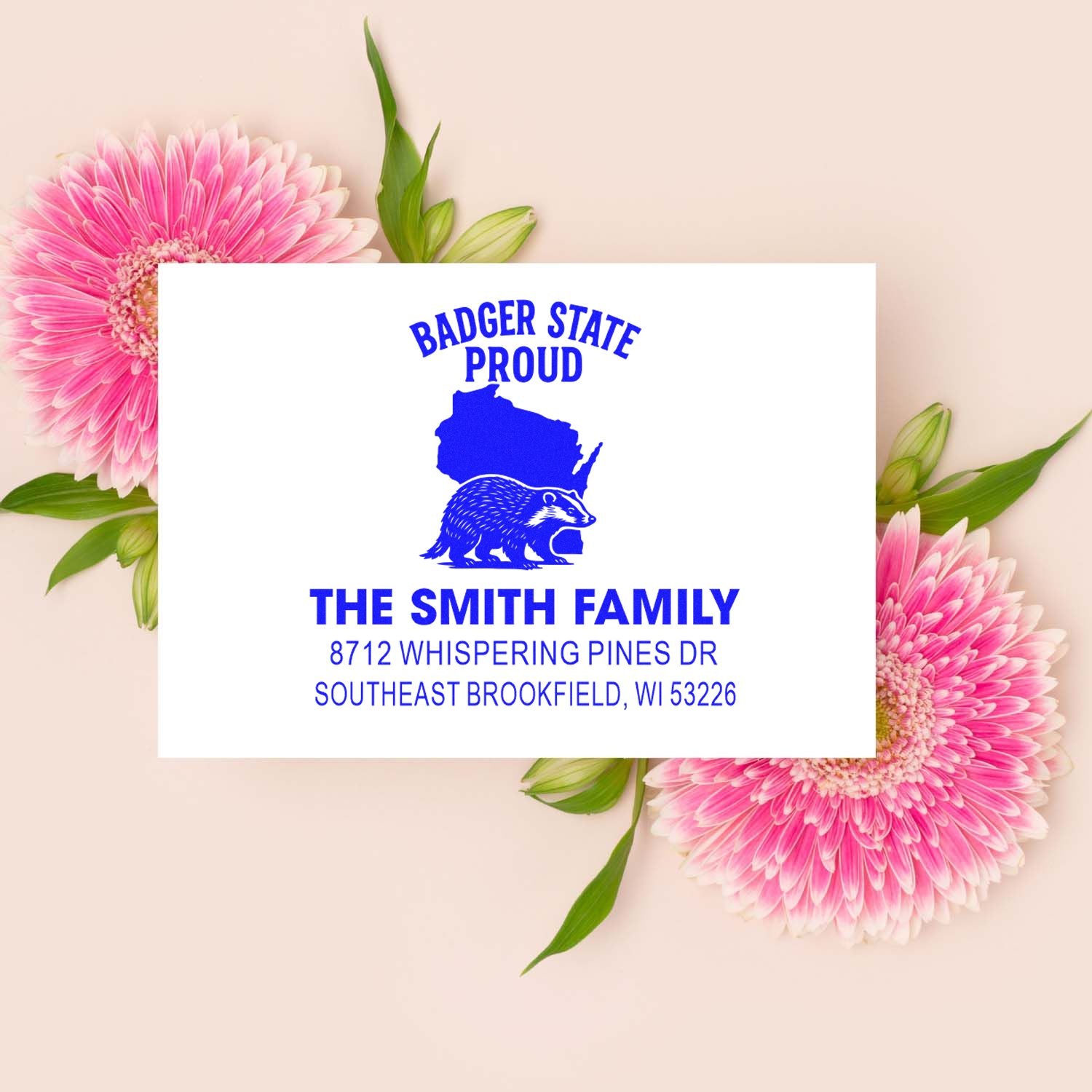 Personalized Wisconsin address stamp for The Smith Family with Badger State Proud logo, set on pink gerbera flowers.