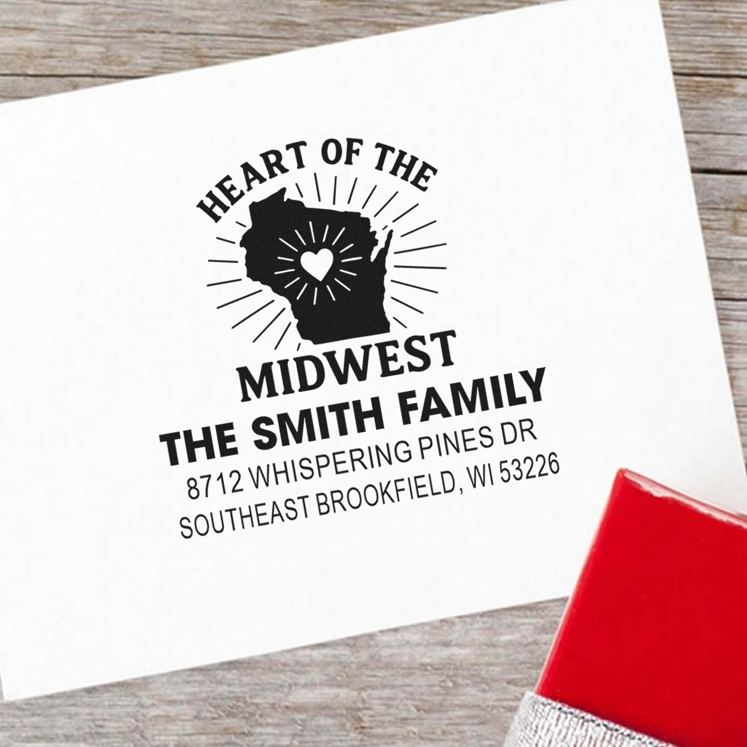 Custom family address stamp with Wisconsin silhouette and heart icon on white paper, featuring The Smith Family in Southeast Brookfield, WI.