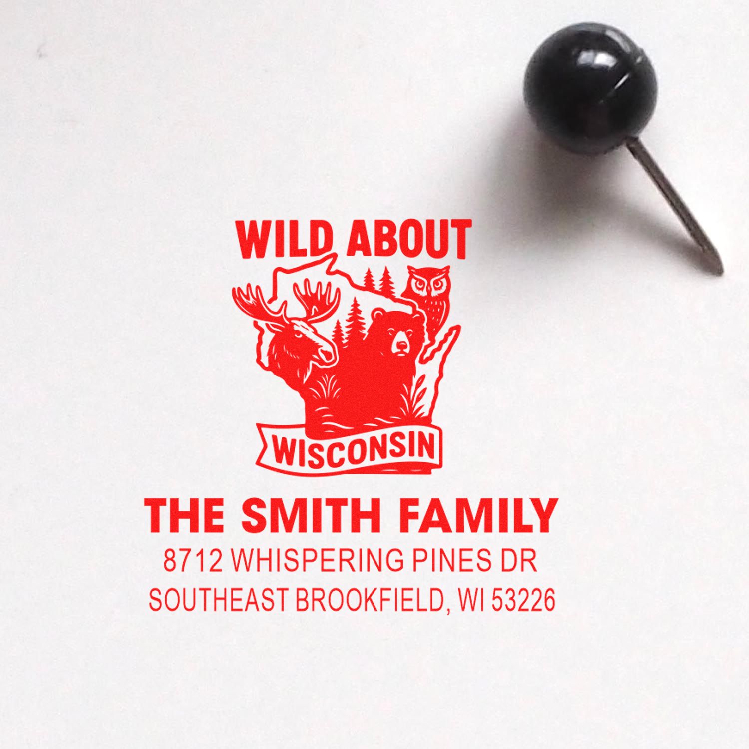 Custom red address stamp with Wisconsin wildlife design reading Wild About Wisconsin for The Smith Family on white paper.