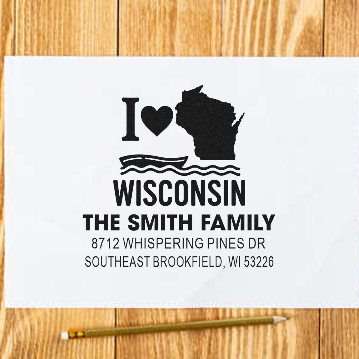 Custom Wisconsin family return address stamp with I love Wisconsin design, state silhouette, waves, and Smith family address on white paper over a wood table.