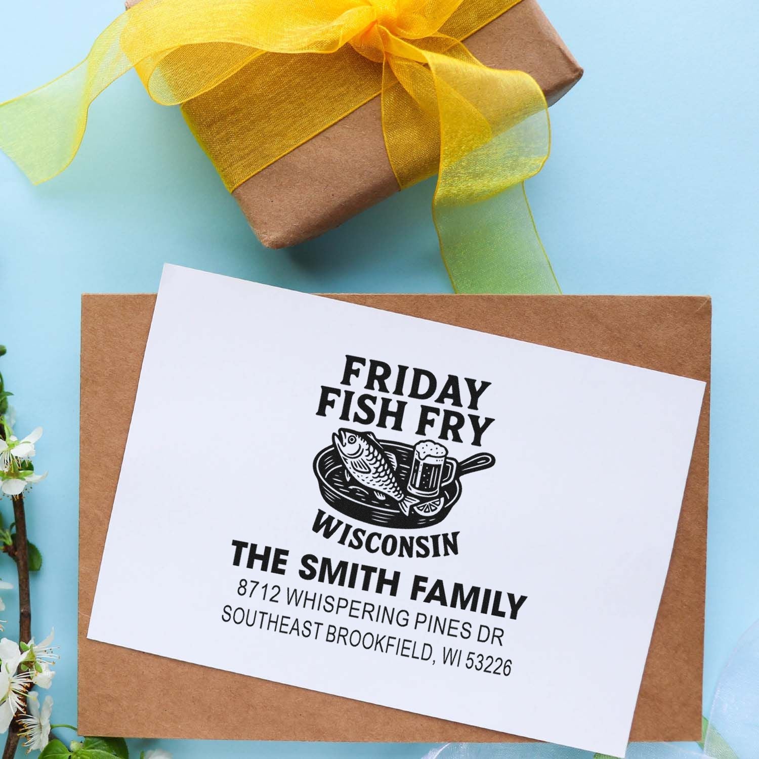 Personalized Friday Fish Fry Wisconsin return address stamp for The Smith Family on kraft envelope with yellow ribbon gift box.