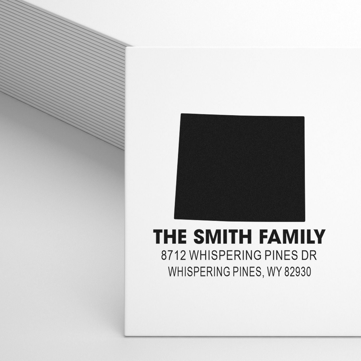 Personalized address stamp mockup for The Smith Family, featuring a black square logo and Whispering Pines address on a clean white background.
