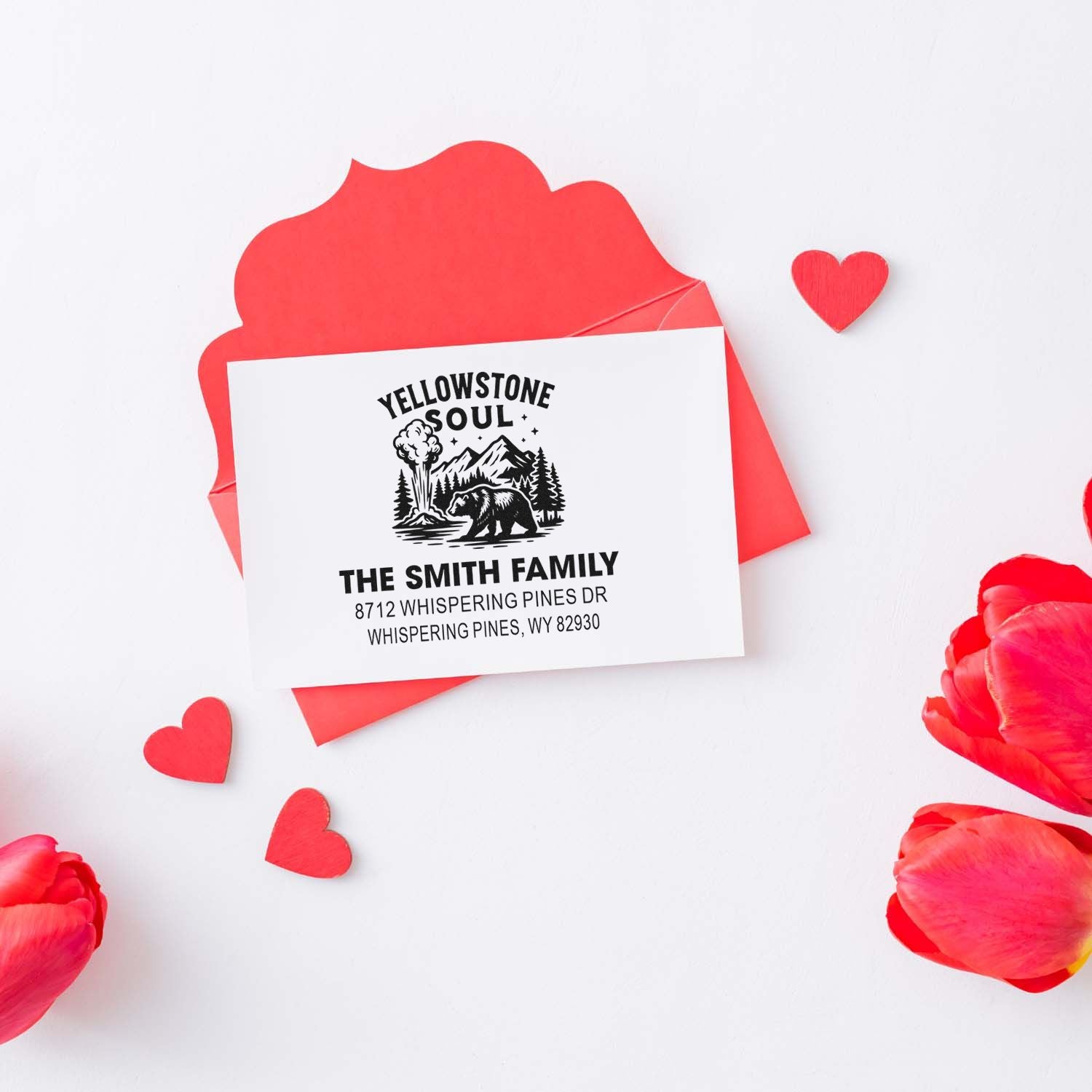 Custom Yellowstone Soul family return address stamp on a red envelope with hearts and tulips, Valentine stationery on a white background.