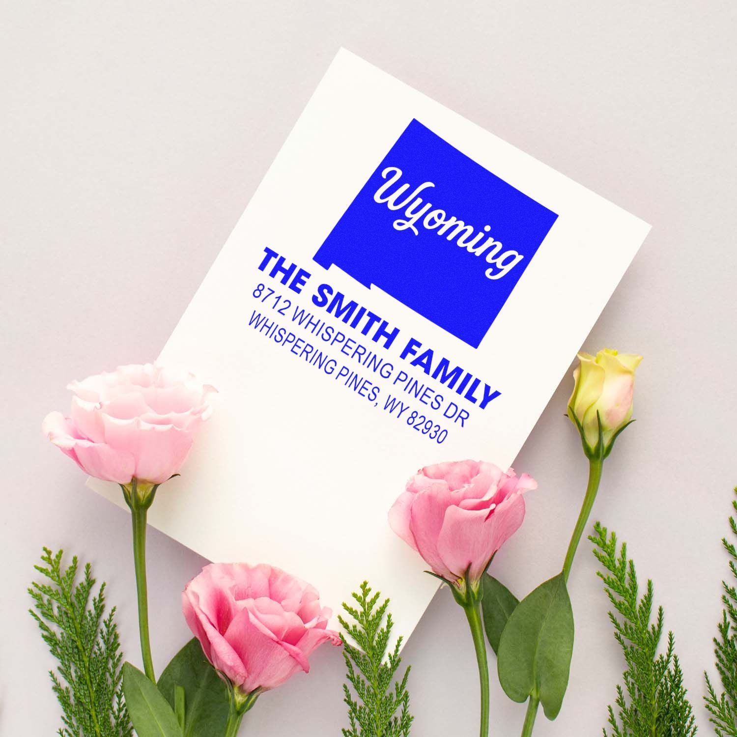 Custom Wyoming address stamp for The Smith Family, surrounded by pink flowers on a soft neutral background.