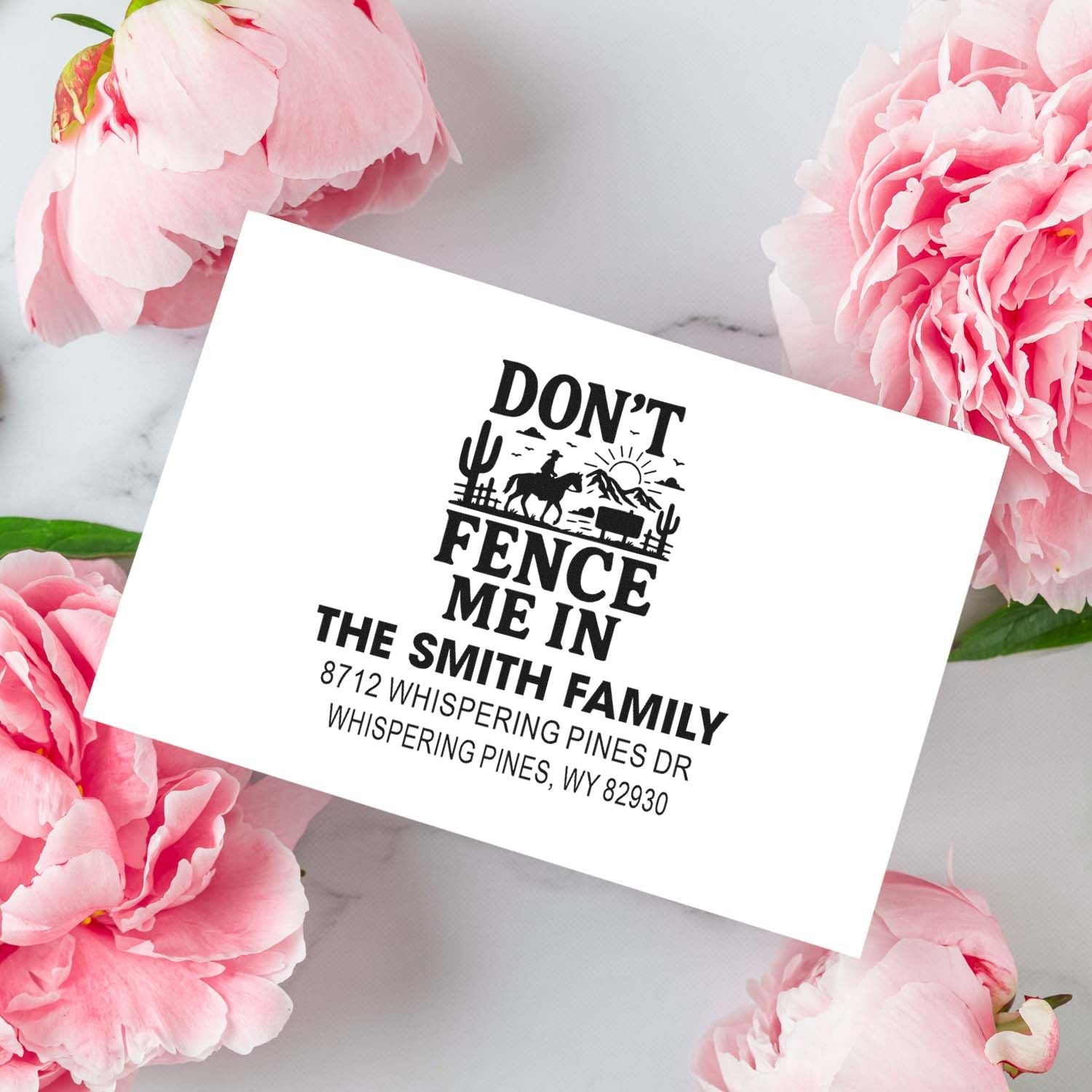 Custom self-inking address stamp with Dont Fence Me In western cowboy design on a marble background with pink peonies.