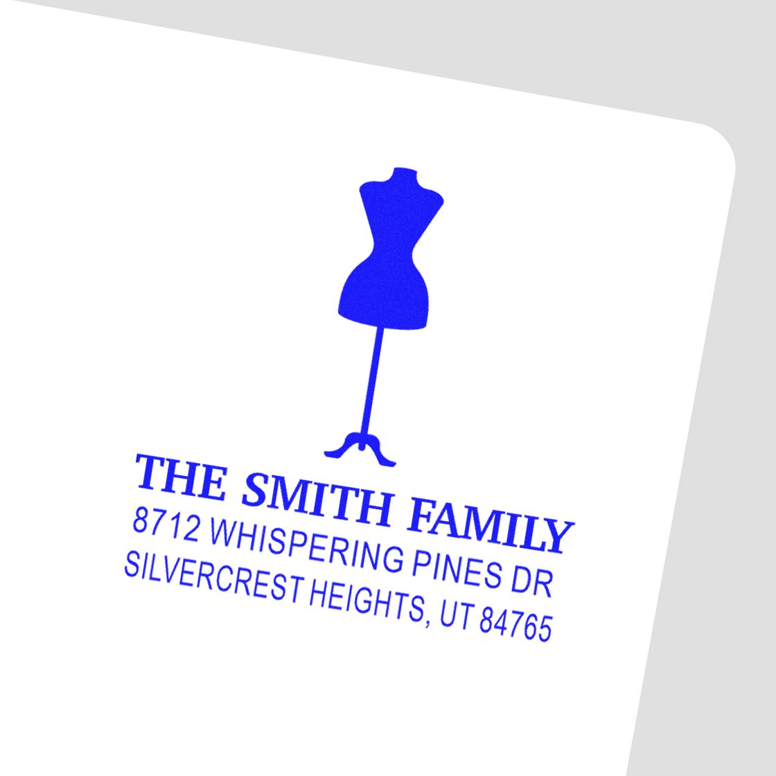 Blue personalized address stamp with dress silhouette for The Smith Family, showing 8712 Whispering Pines Dr, Silvercrest Heights, UT 84765.