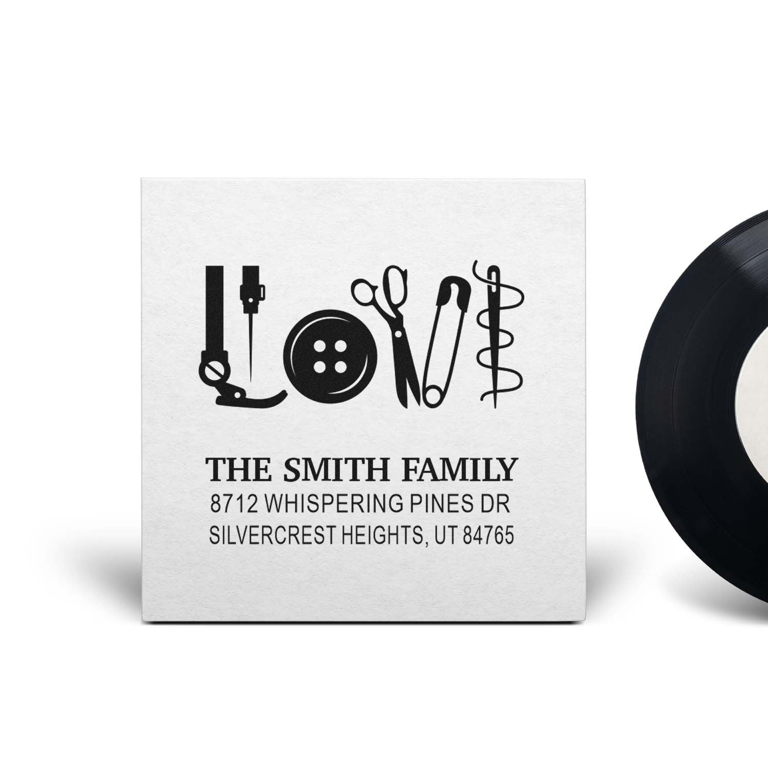 Custom personalized rubber stamp with sewing tools spelling LOVE, featuring The Smith Family name and address on a white product mockup.