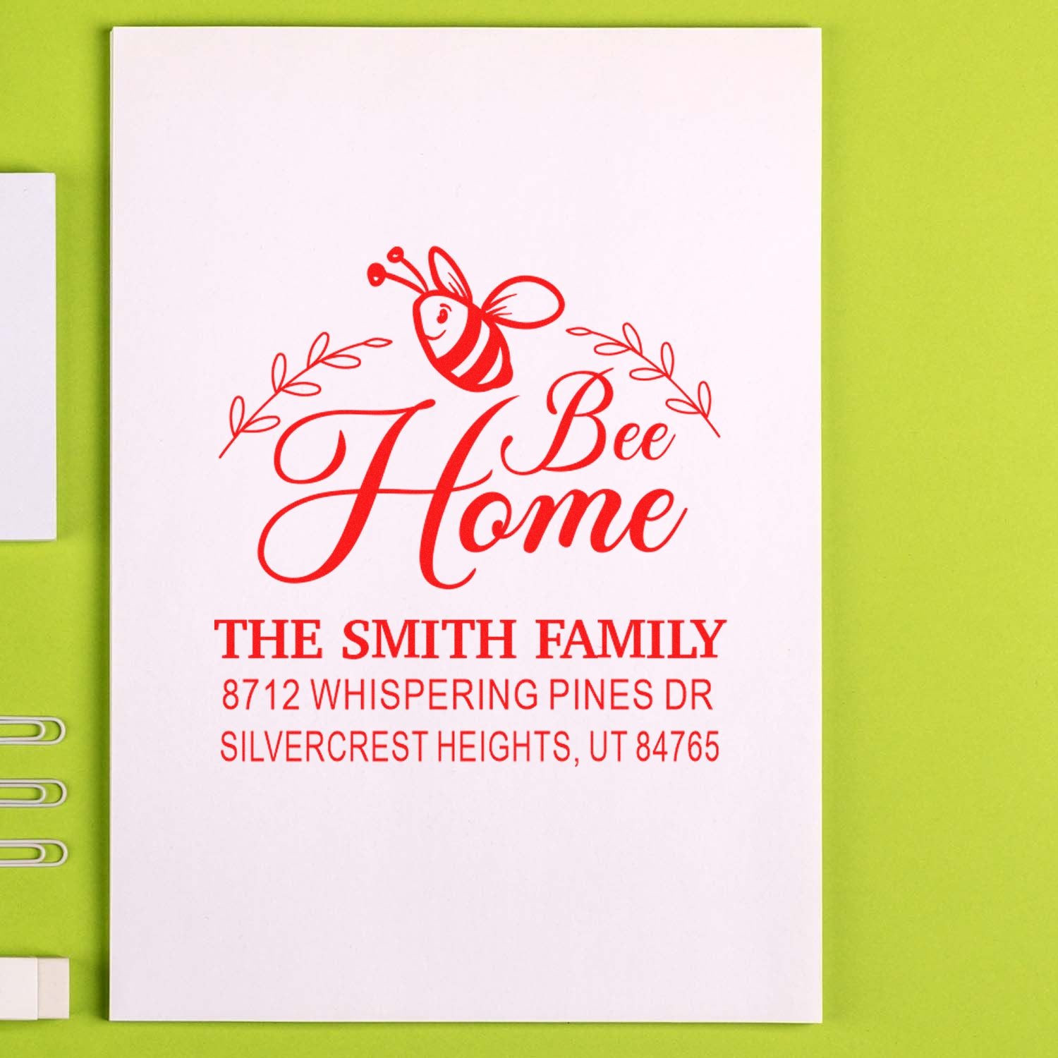 Custom red Bee Home address stamp with bee graphic, The Smith Family and Utah address on a white card against a lime green background.