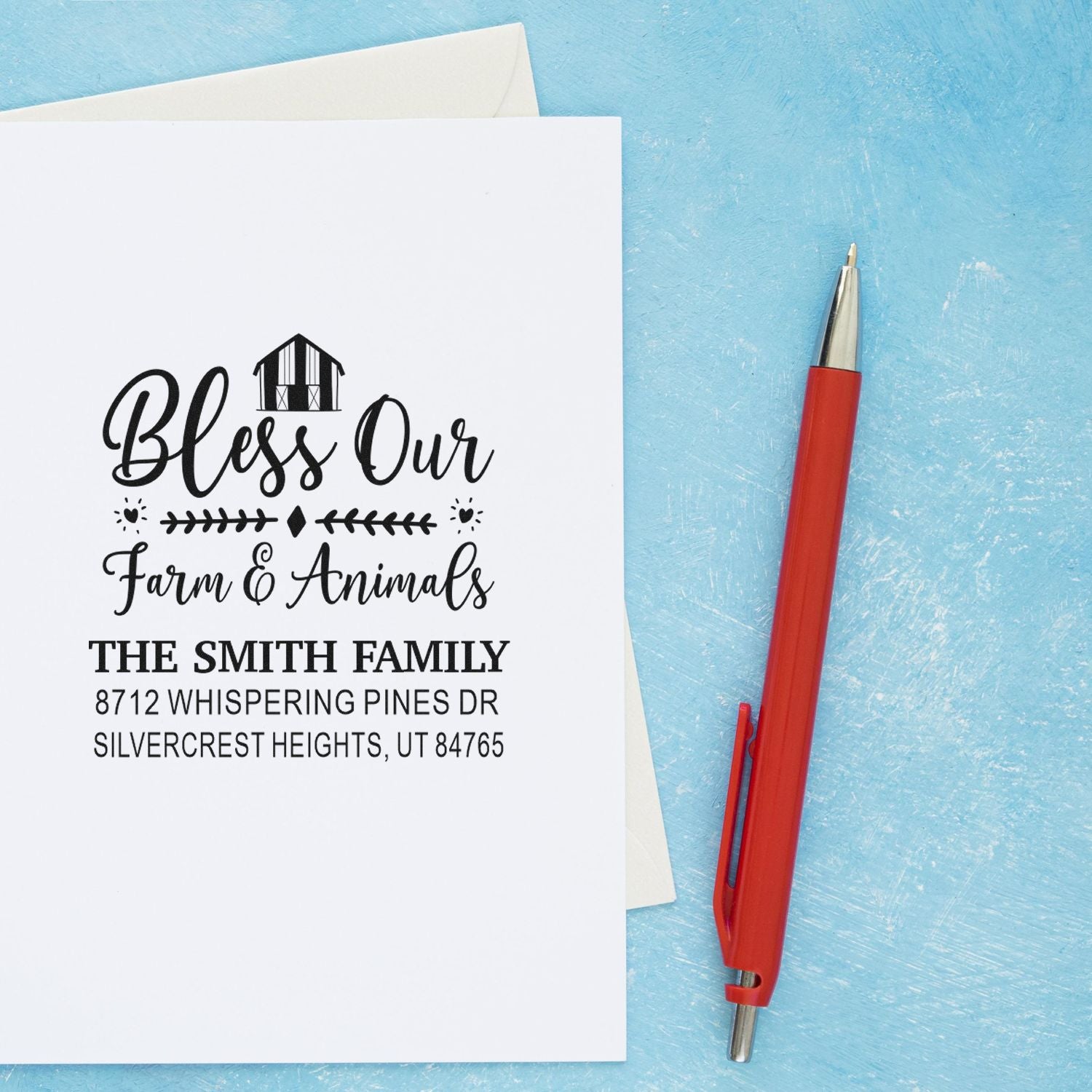 Personalized farm and animal return address stamp on white envelope with red pen on blue background, featuring The Smith Family and barn design.