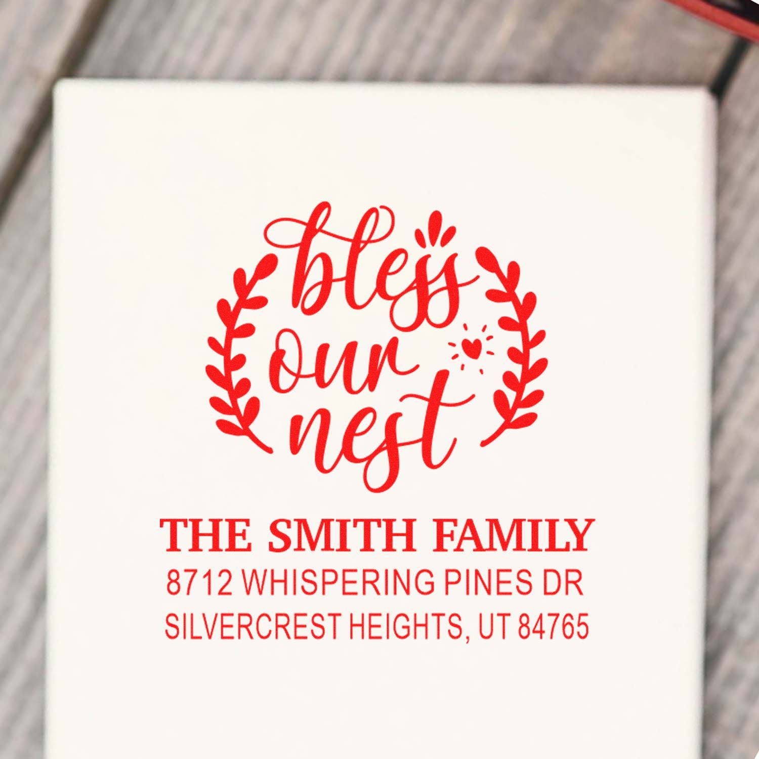 Custom red personalized address stamp with bless our nest and The Smith Family address on a white package.
