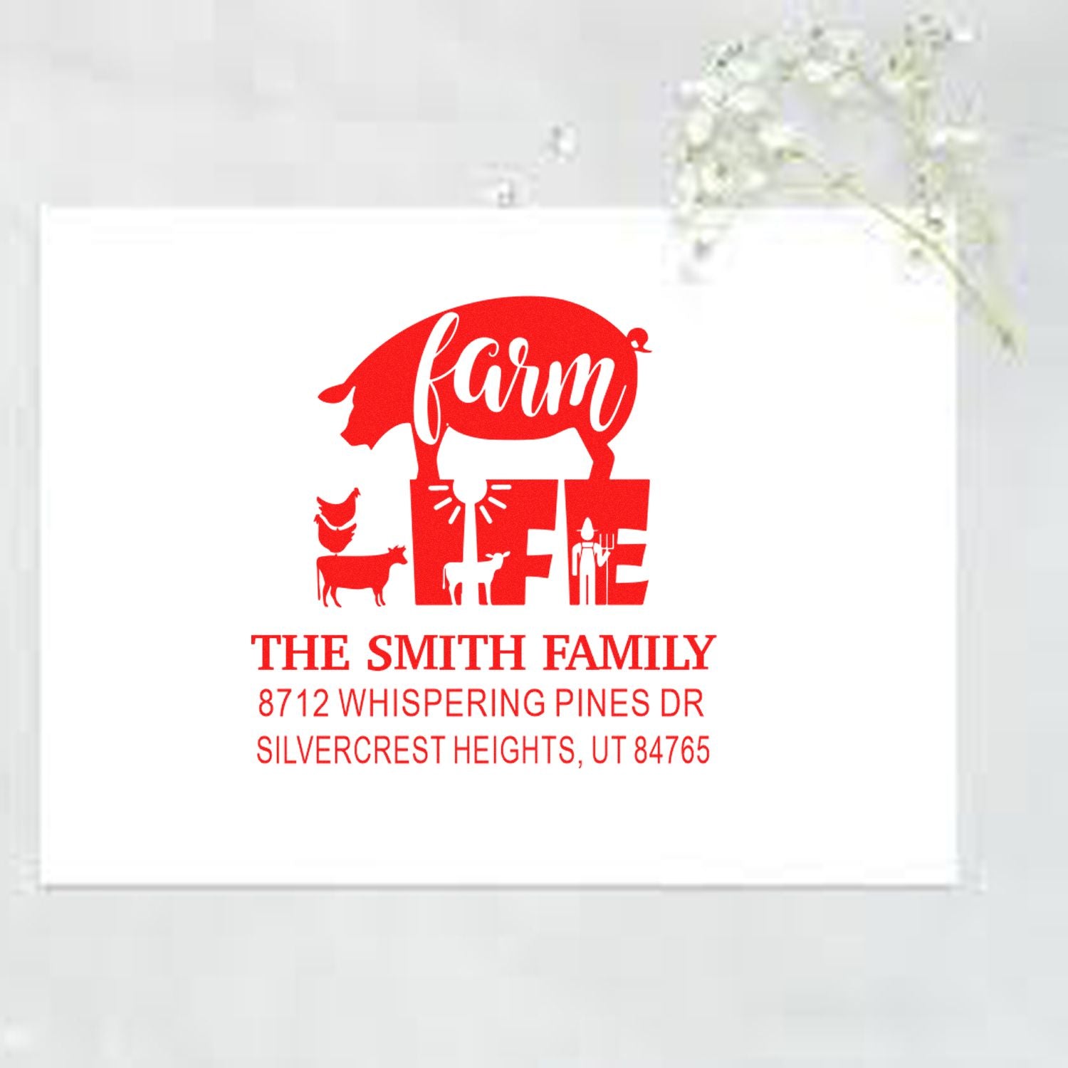 Custom red farmhouse return address stamp with pig, chickens and cow for The Smith Family, displayed on white card with floral decor.