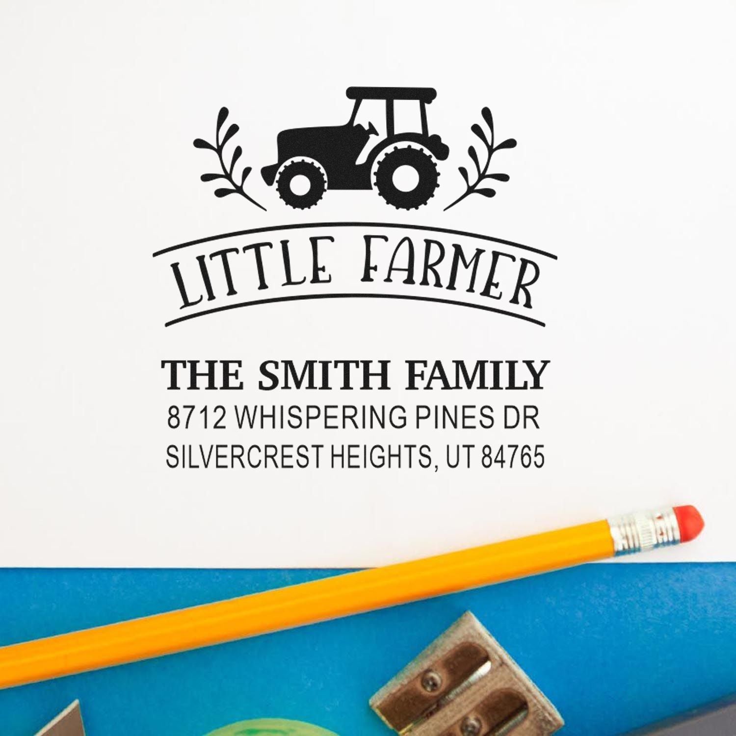 Personalized Little Farmer return address stamp with tractor design, Smith family name and address on white paper, beside a pencil and school supplies.