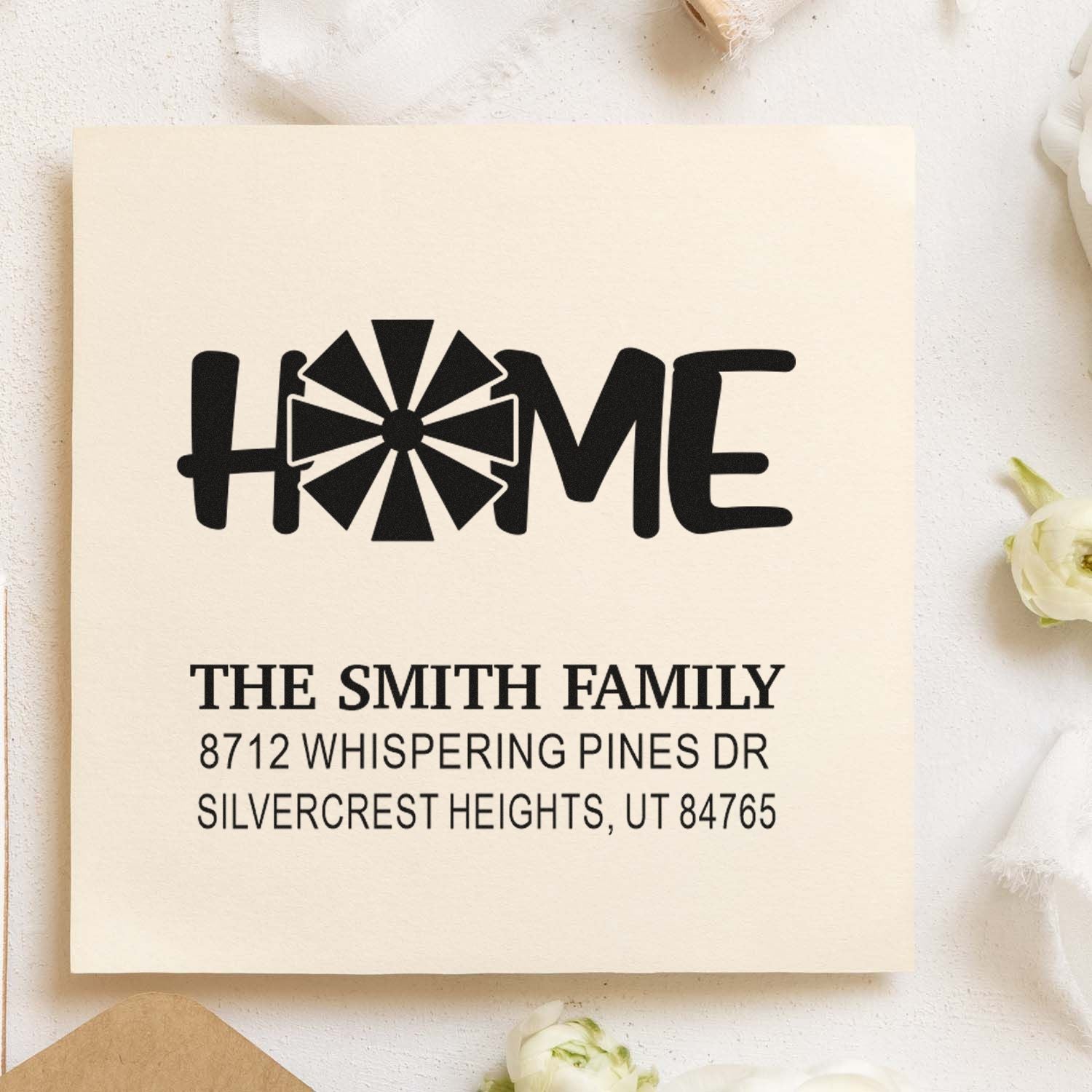 Custom family address stamp with HOME windmill design and The Smith Family address on cream paper with flowers.