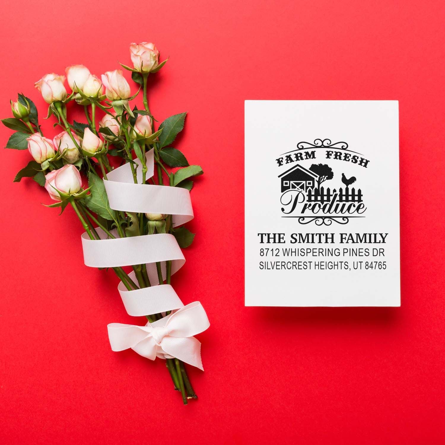 Custom farm fresh produce address stamp beside a ribbon-tied bouquet of pink roses on a bright red background.