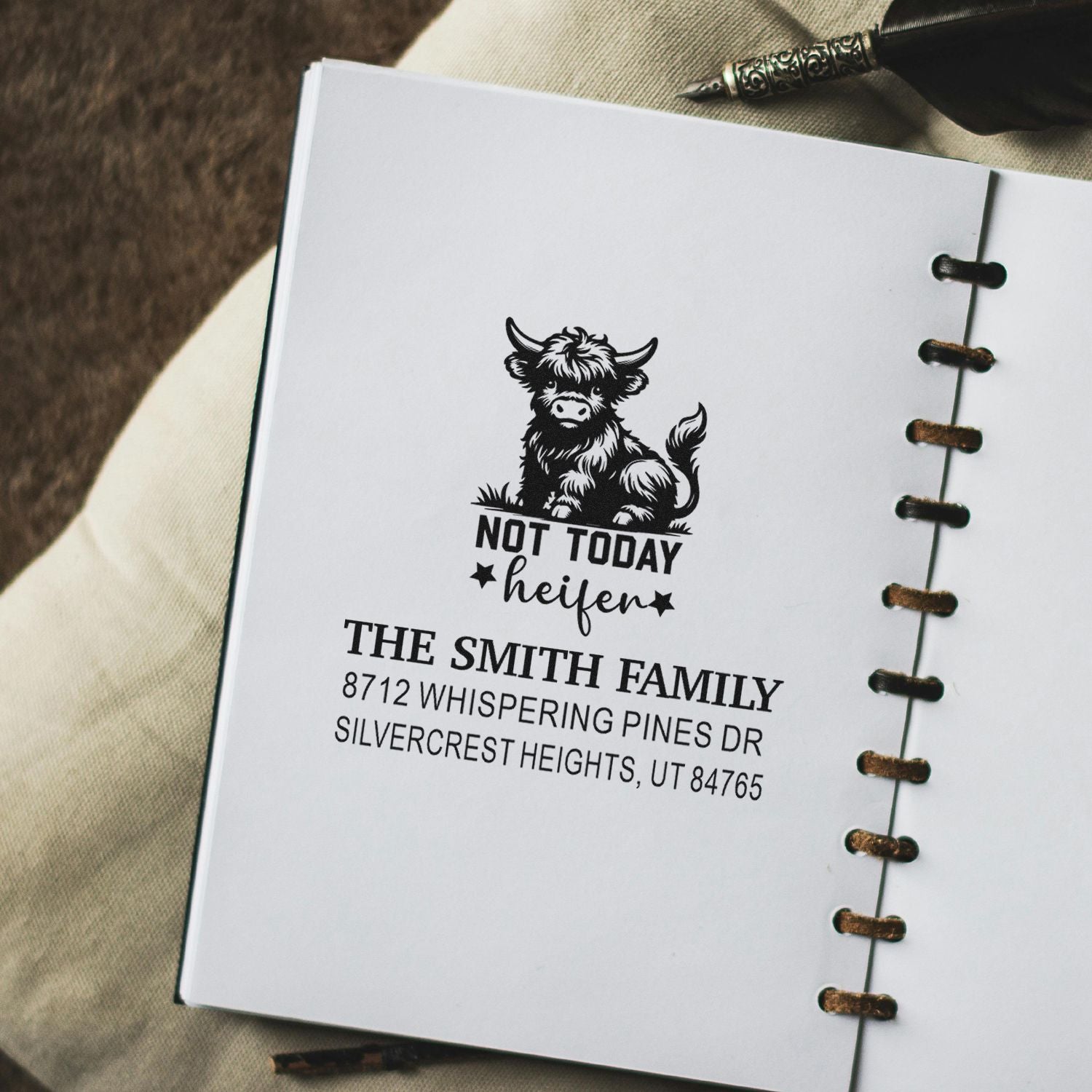 Custom rubber stamp on notebook page featuring a cow and Not Today heifer with The Smith Family address, beside a fountain pen.