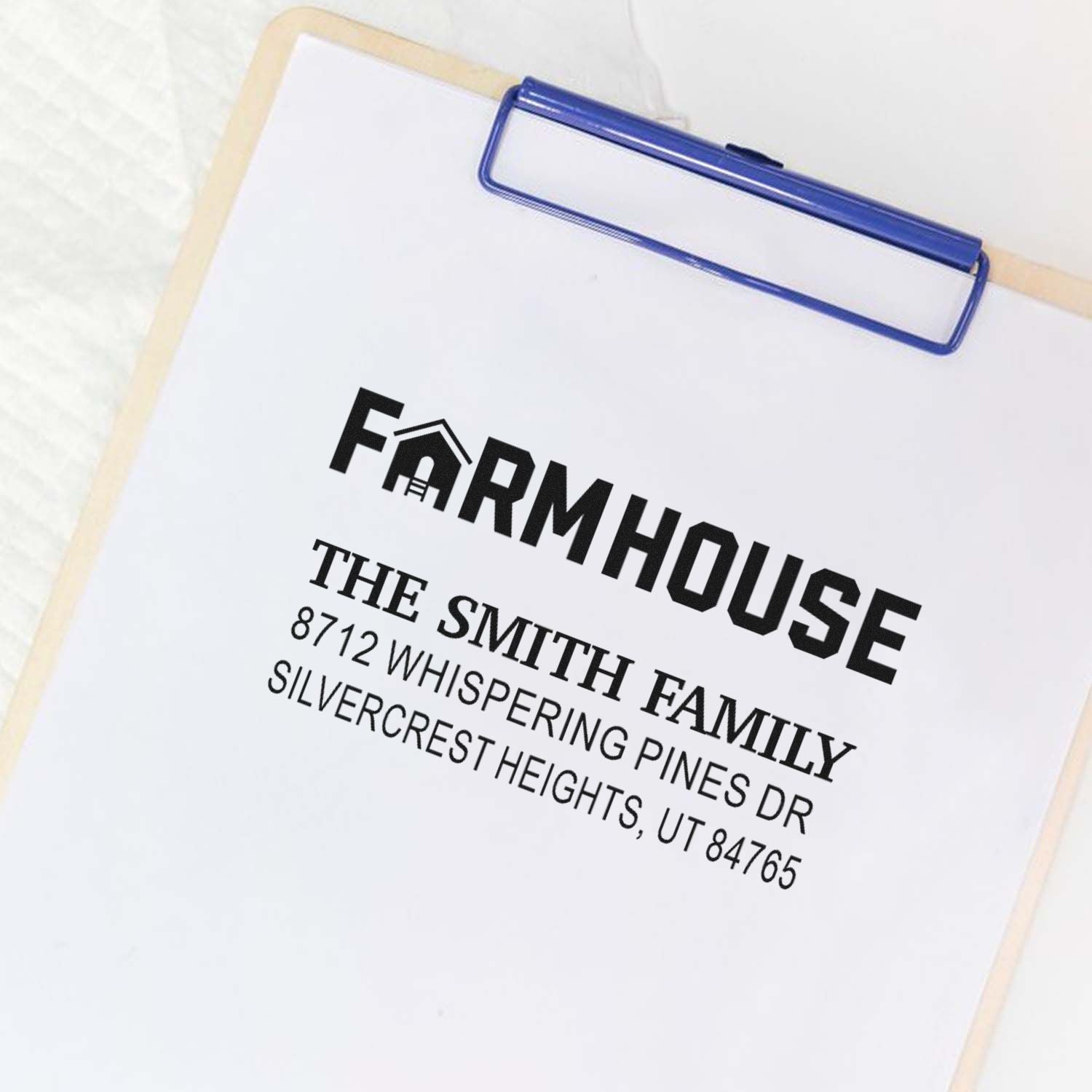 Personalized farmhouse address stamp on a clipboard, showing The Smith Family name and Utah mailing address on white paper.
