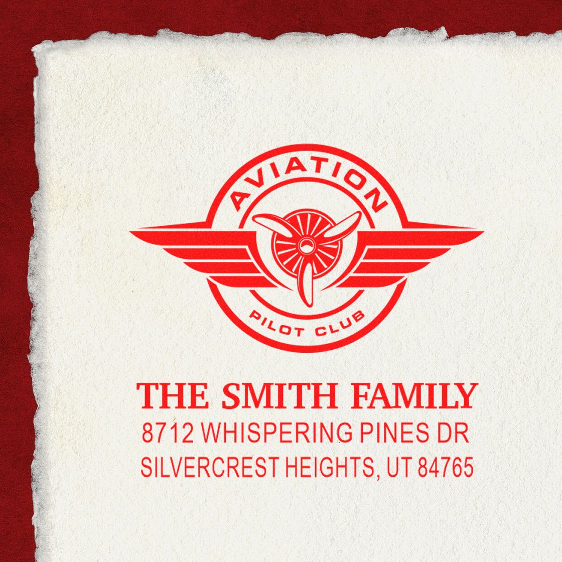 Custom red aviation pilot club address stamp for The Smith Family, with winged propeller logo and Silvercrest Heights, UT address on textured paper.