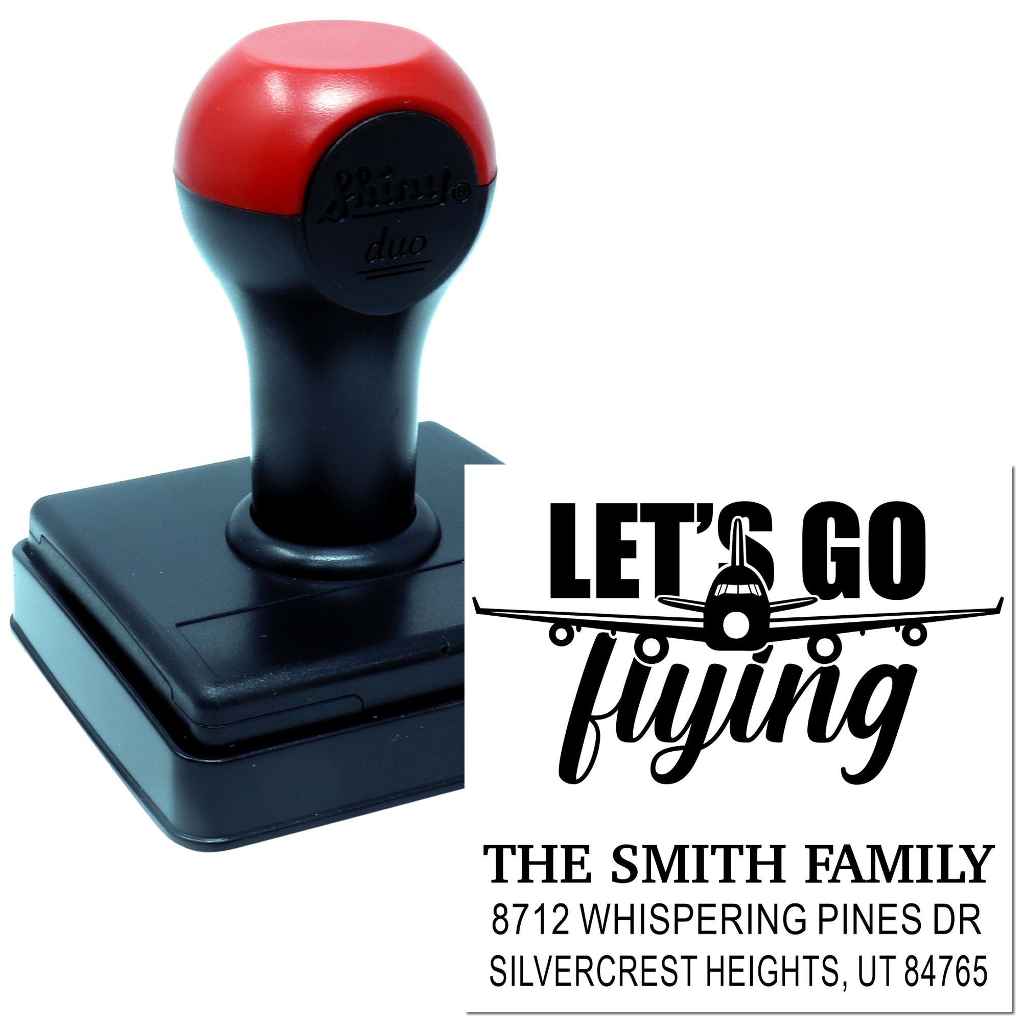 Custom self-inking stamp with airplane design and Lets Go Flying return address imprint for The Smith Family on a white background.