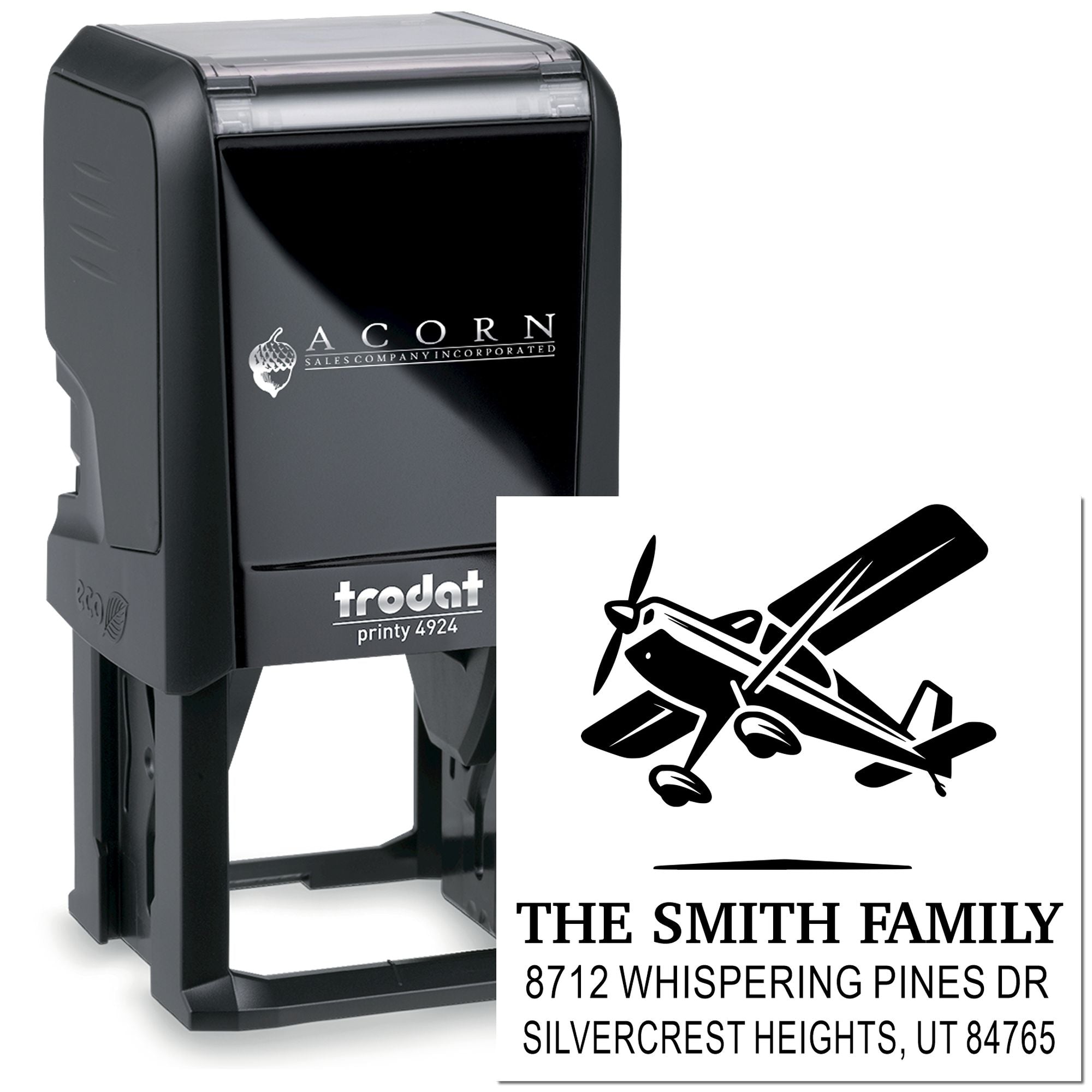 Custom self-inking Trodat printy stamp with airplane logo and The Smith Family address, shown beside the stamped impression on white background.
