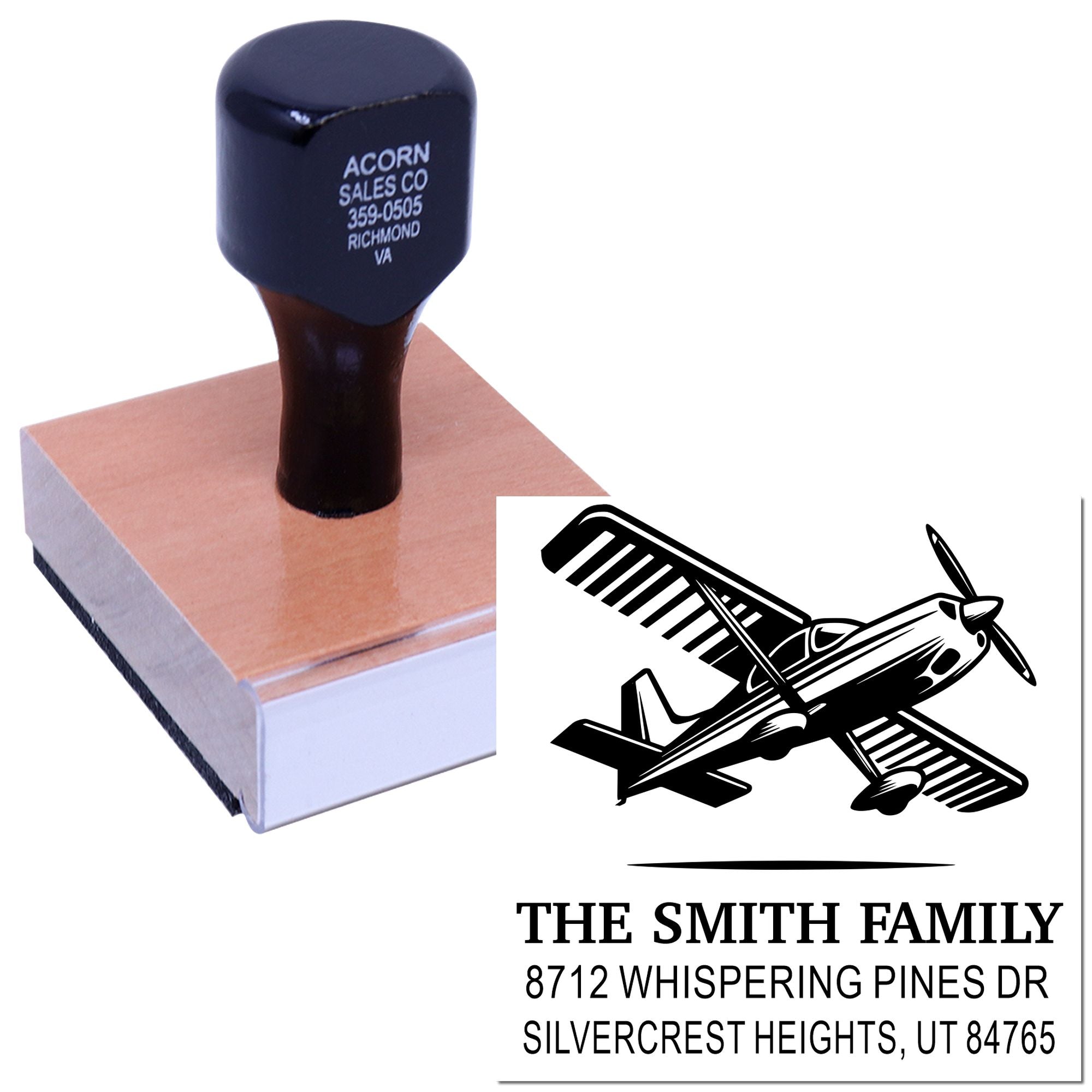 Custom self-inking rubber stamp with airplane logo and family address, shown on a block pressing a clear pad with printed sample imprint.