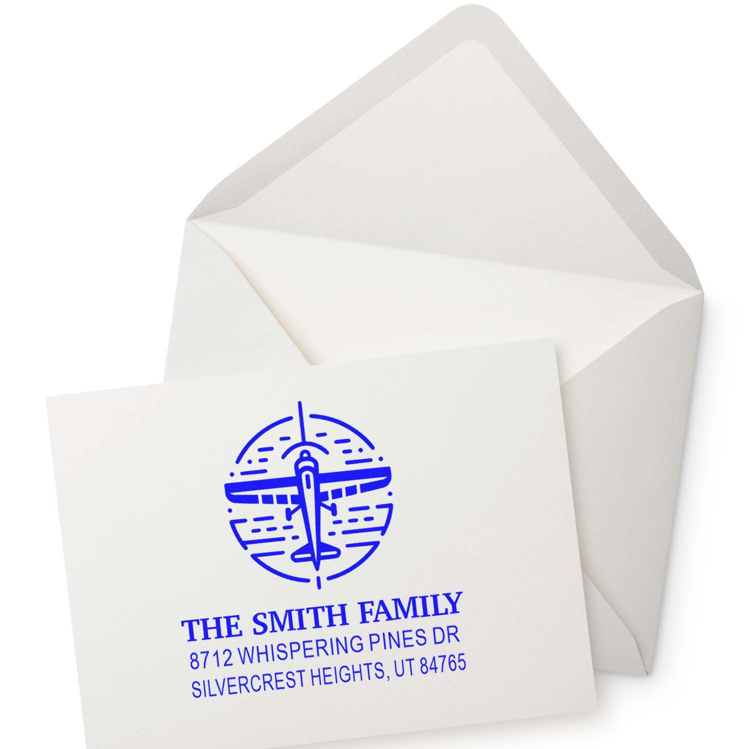Custom blue airplane return address stamp on white envelope, featuring The Smith Family and address details.