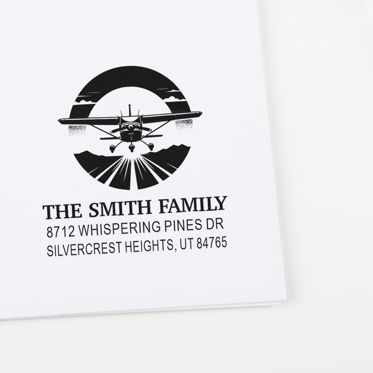 Personalized return address stamp for The Smith Family with airplane logo, featuring Utah address on white paper.