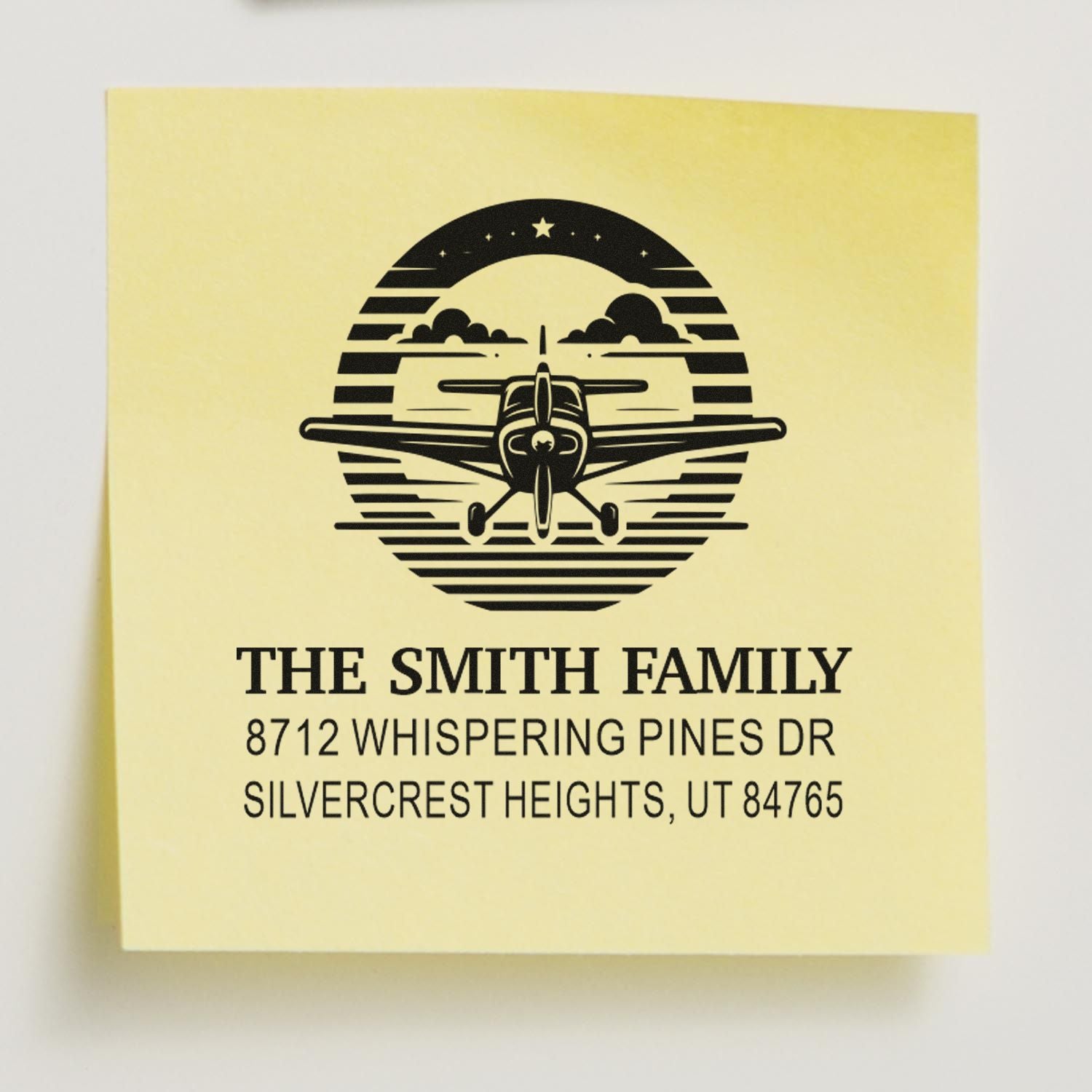 Custom address stamp with airplane logo and The Smith Family text on yellow paper, showing 8712 Whispering Pines Dr, Silvercrest Heights, UT 84765.
