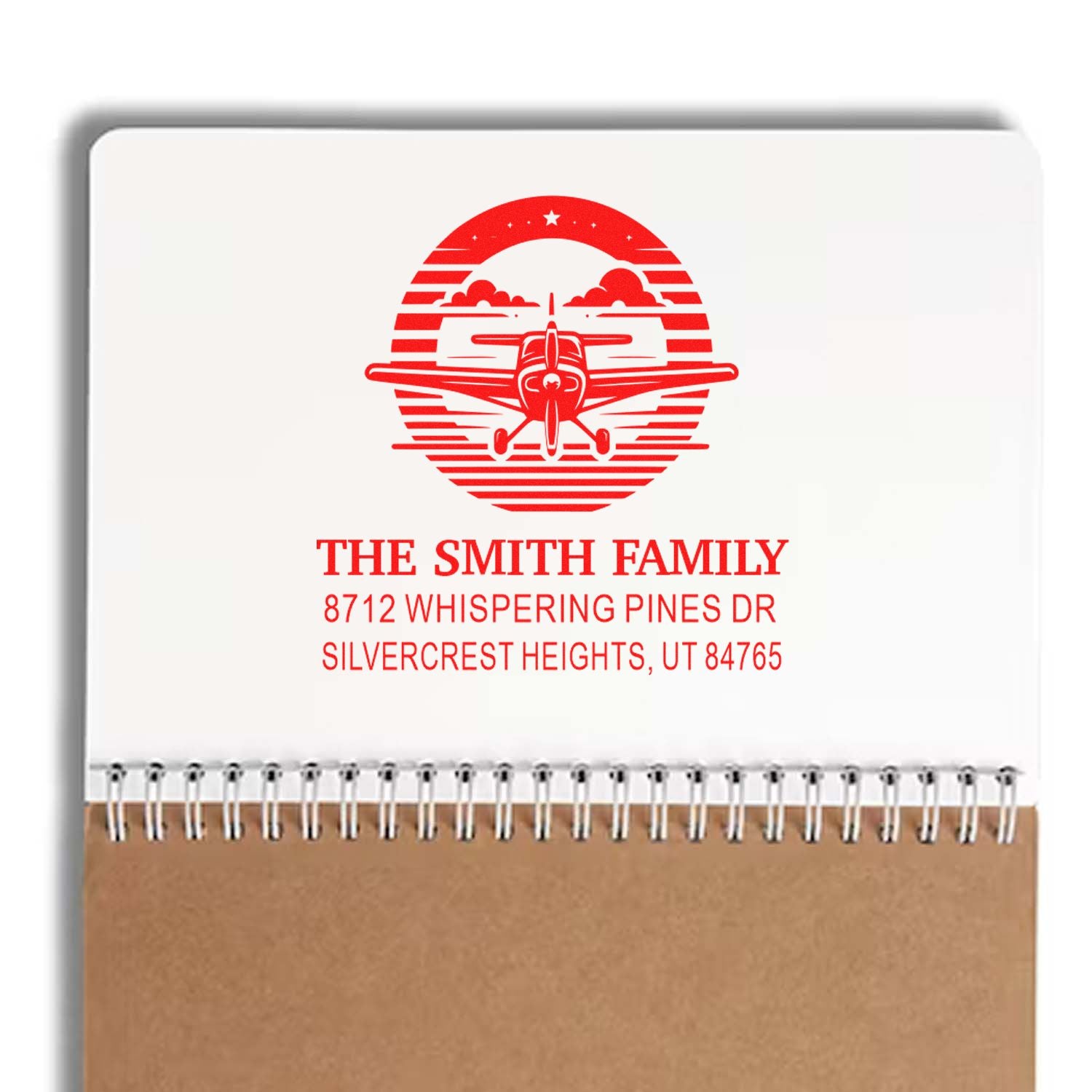 Custom return address stamp with red airplane logo, The Smith Family and Utah address on a notepad-style product display.