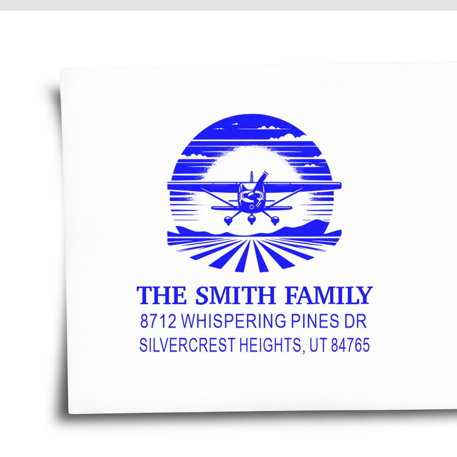 Blue custom self-inking address stamp for The Smith Family, featuring an airplane, sunset landscape, and Whispering Pines Dr, Silvercrest Heights, UT.