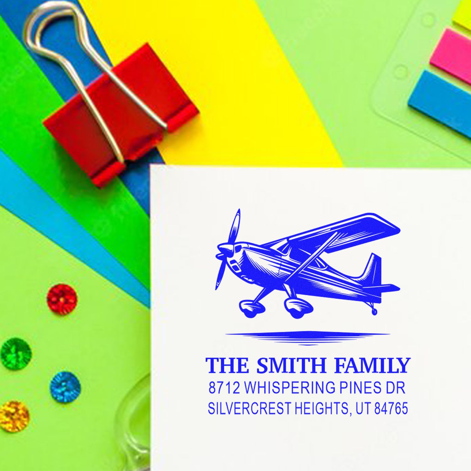 Airplane return address stamp for The Smith Family on colorful stationery with binder clip and sticky notes.