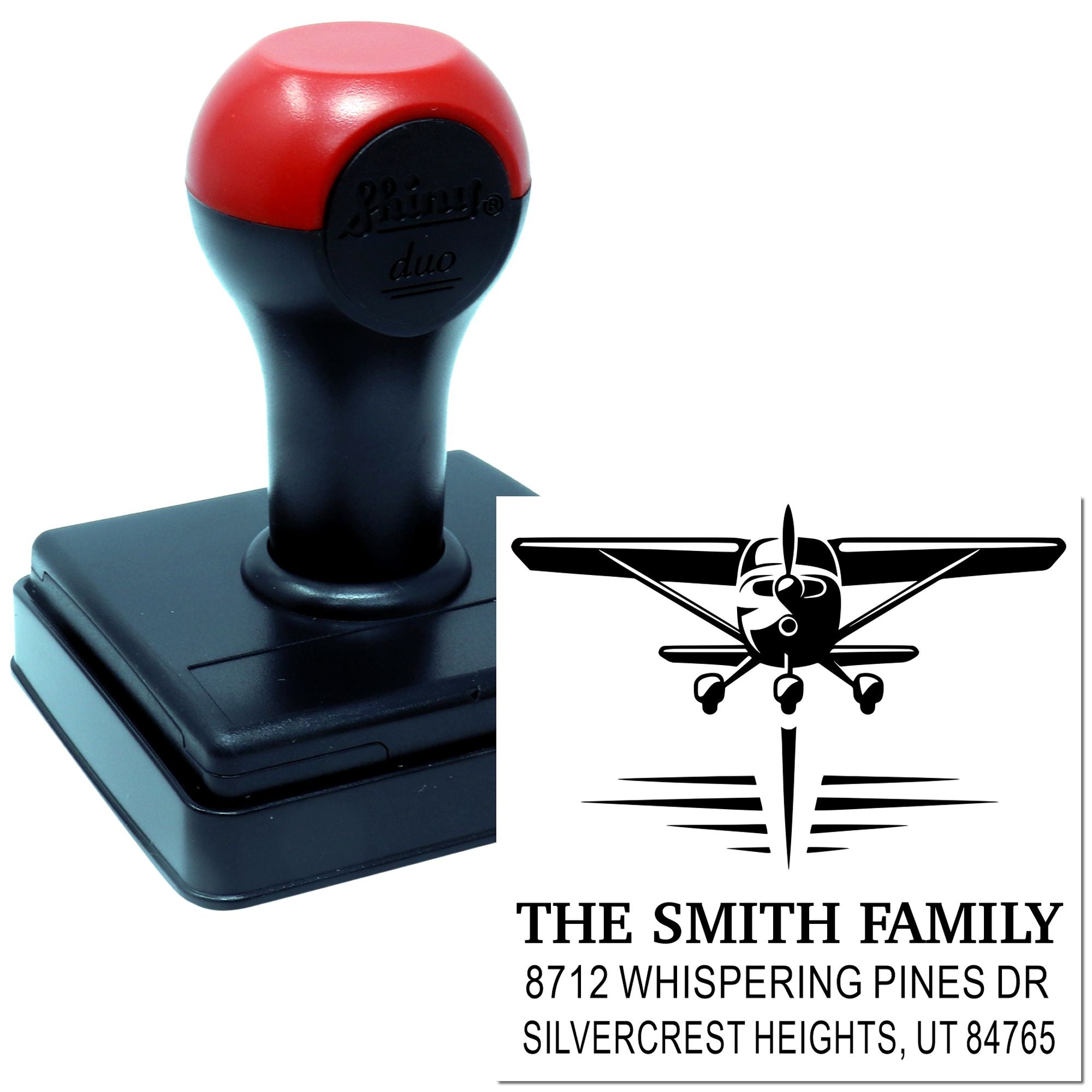 Custom self-inking address stamp with airplane logo, The Smith Family return address, and black/red stamp handle on white background.