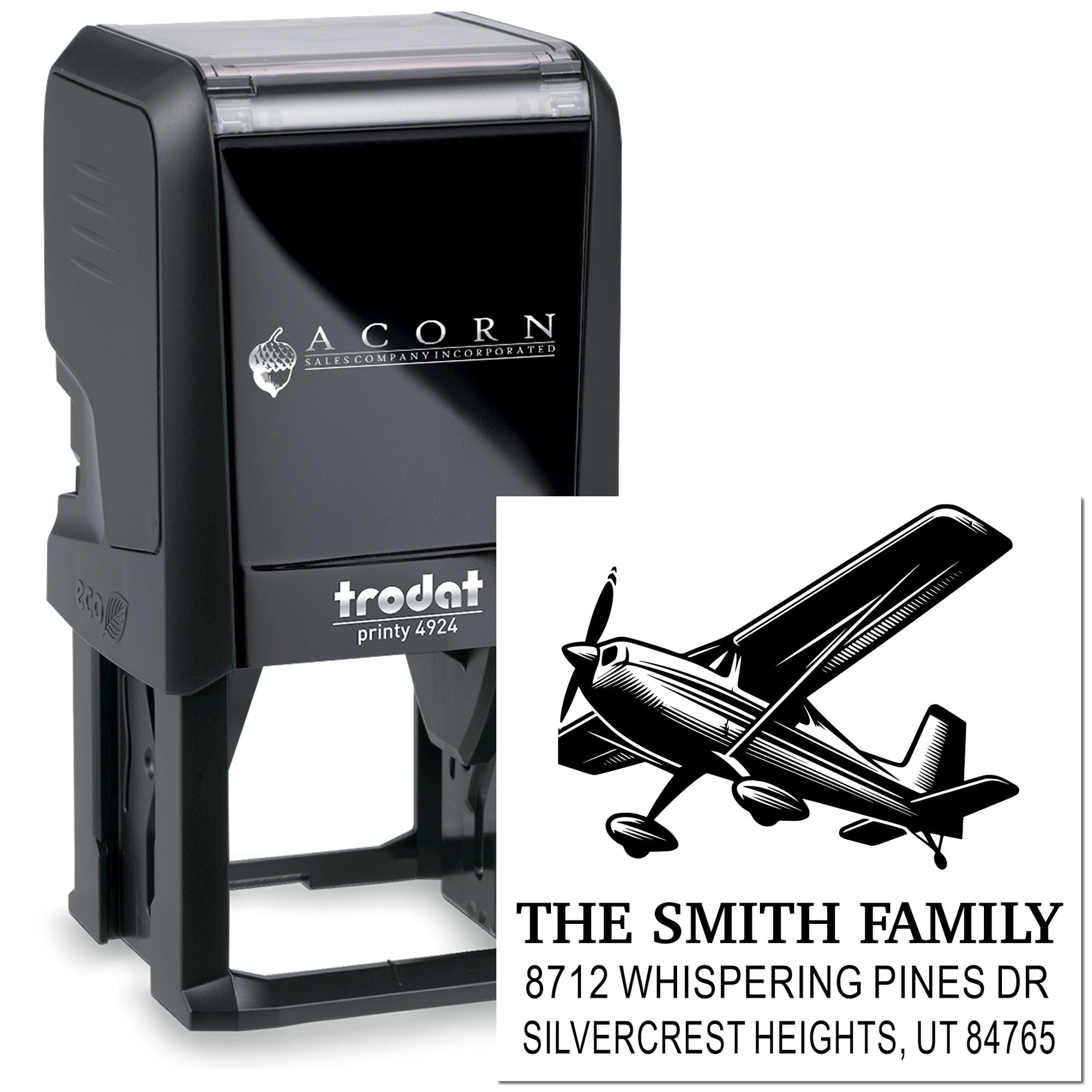 Custom self-inking Trodat Printy 4924 address stamp with airplane logo, family name, and return address on white background.