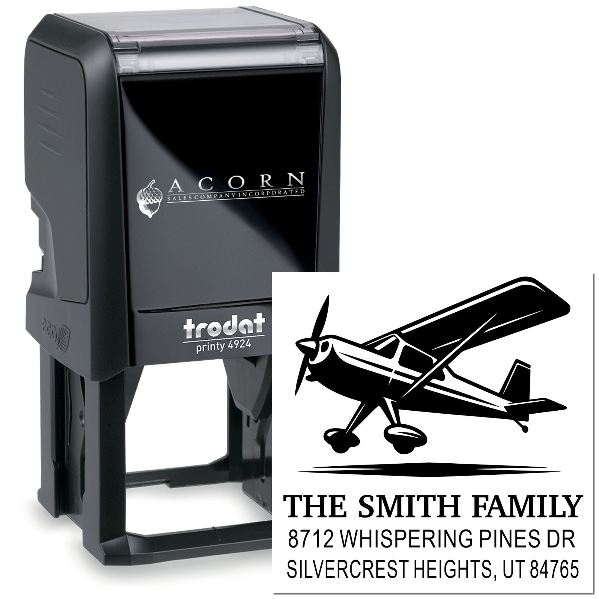 Black Trodat self-inking custom address stamp with airplane logo and The Smith Family mailing address on a white background.