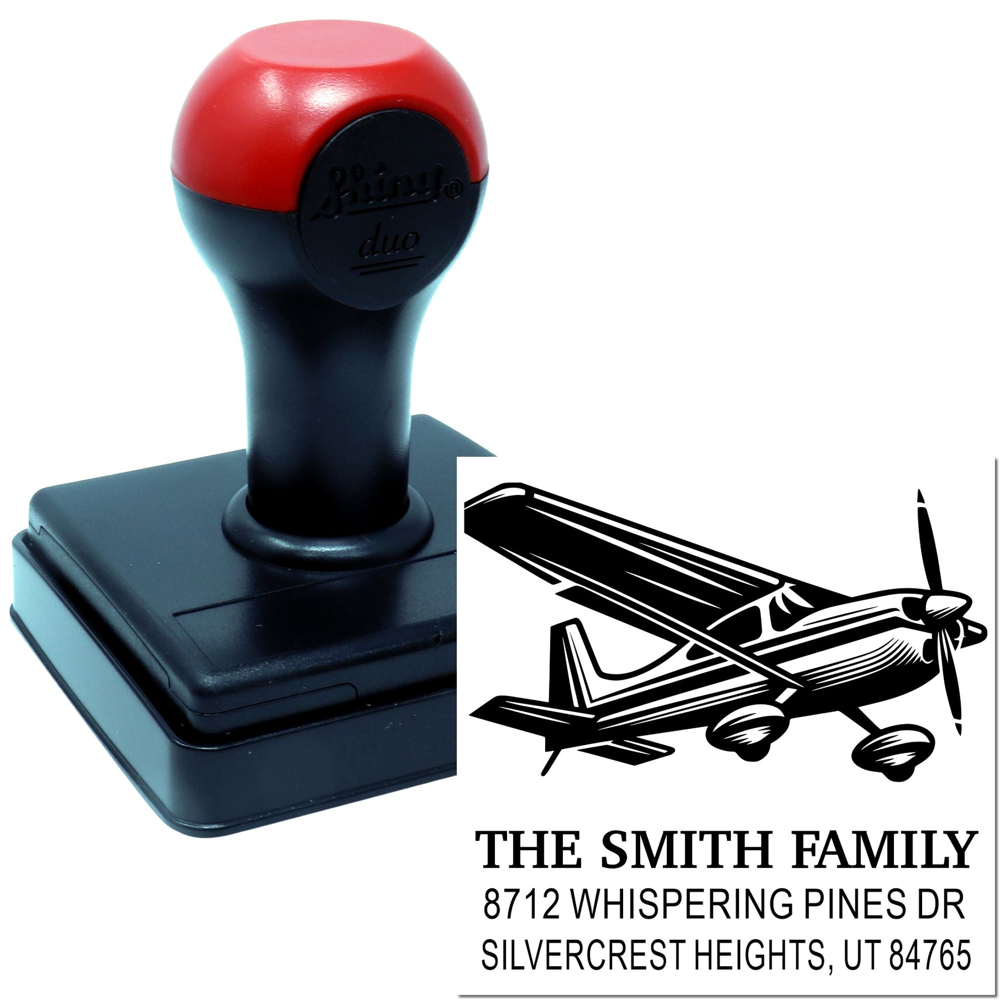 Custom self-inking address stamp with airplane design, black-and-red handle, and sample imprint for The Smith Family in Silvercrest Heights, UT.