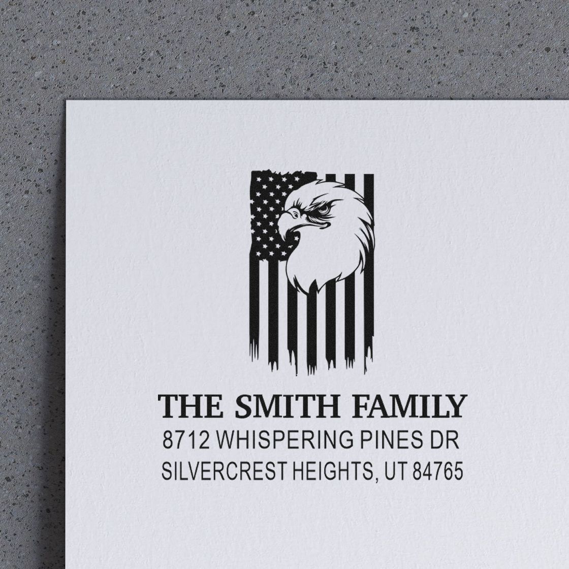 Custom address stamp with eagle and American flag design on white paper, reading The Smith Family, 8712 Whispering Pines Dr, Silvercrest Heights, UT.