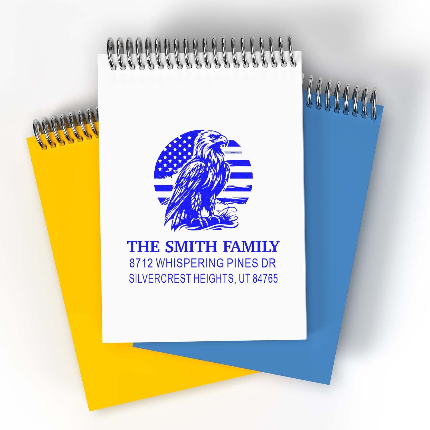 Custom family address stamp with eagle and American flag design on spiral notebooks, featuring The Smith Family and a Utah address.
