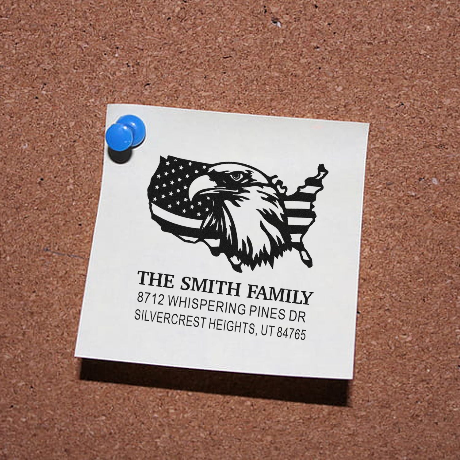 Custom family return address stamp with eagle and U.S. flag map design, pinned to a corkboard, reading The Smith Family, Silvercrest Heights, UT.
