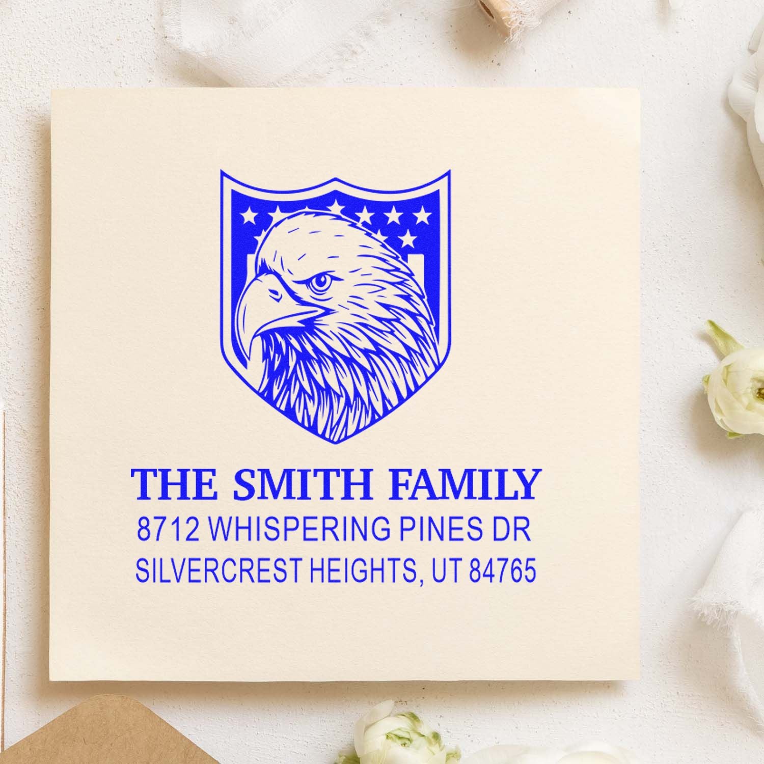 Custom family address rubber stamp with eagle crest, blue ink design, personalized name, street address, city, state and ZIP for mailing.